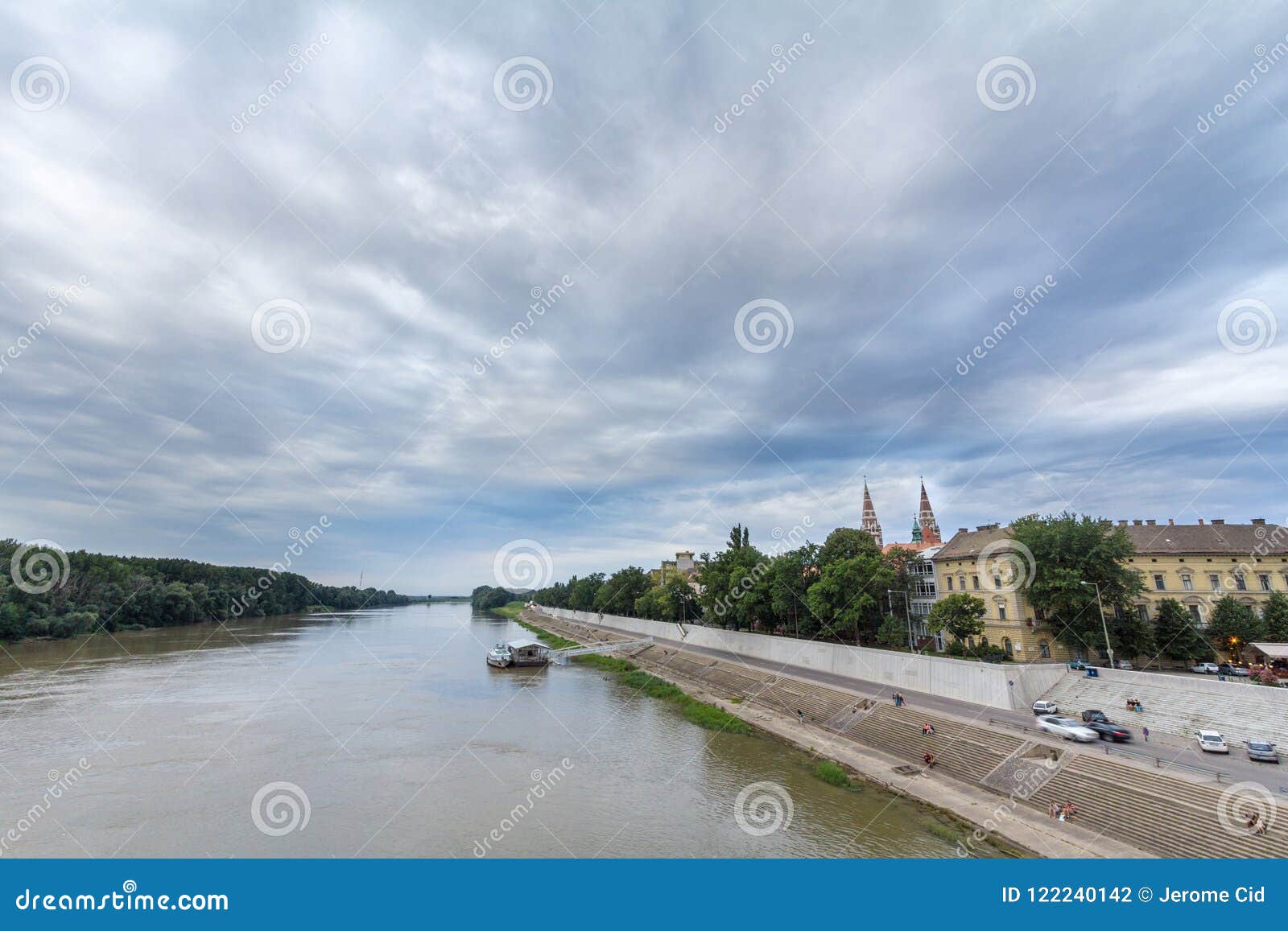 Het centrum van de Szegedstad van de rivier van Tisza, met een hoogtepunt op Szeged-Kathedraal wordt, in het licht tijdens zonson. Beeld van het stadscentrum van Szeged, met de torens van Katholieke die dom van Kathedraalszegedi in hoogtepunt, op de banken van de rivier van Tisza wordt gezien