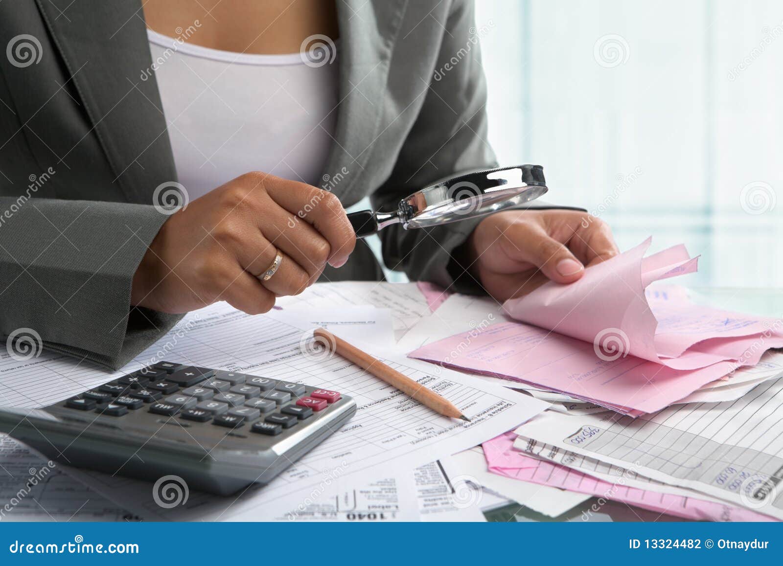 Het controleren van rekeningen met vergrootglas. Onderneemster die rekeningen controleert die vergrootglas in het bureau met behulp van