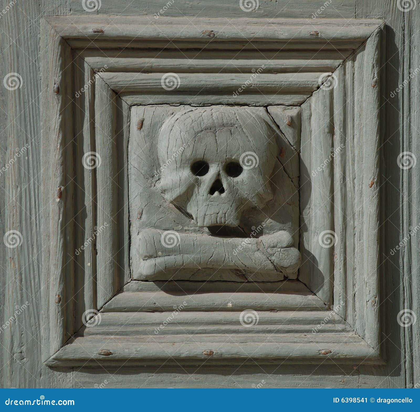 Het Detail van de schedel, Chiesa del Purgatorio. De 18de eeuw Chiesa del Purgatorio (?Kerk van het Vagevuur?) in Matera, Basilicata, zuidelijk Italië. Dit is een detail van de houten deur die in 36 panelen, elk met een schedel op het verdeeld is.