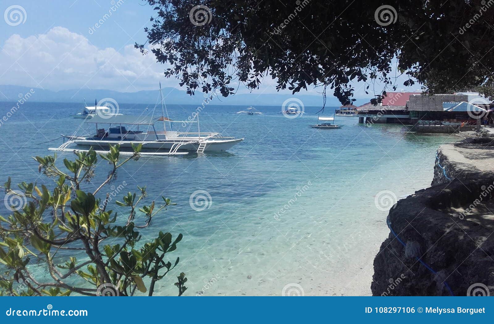 Het doorzichtige eiland Filippijnen van watercebu. Natuurlijke landschappen van Filippijnen 

Blauw water met boot zonnige natuurlijke dag 

Het eiland Filippijnen van Cebu