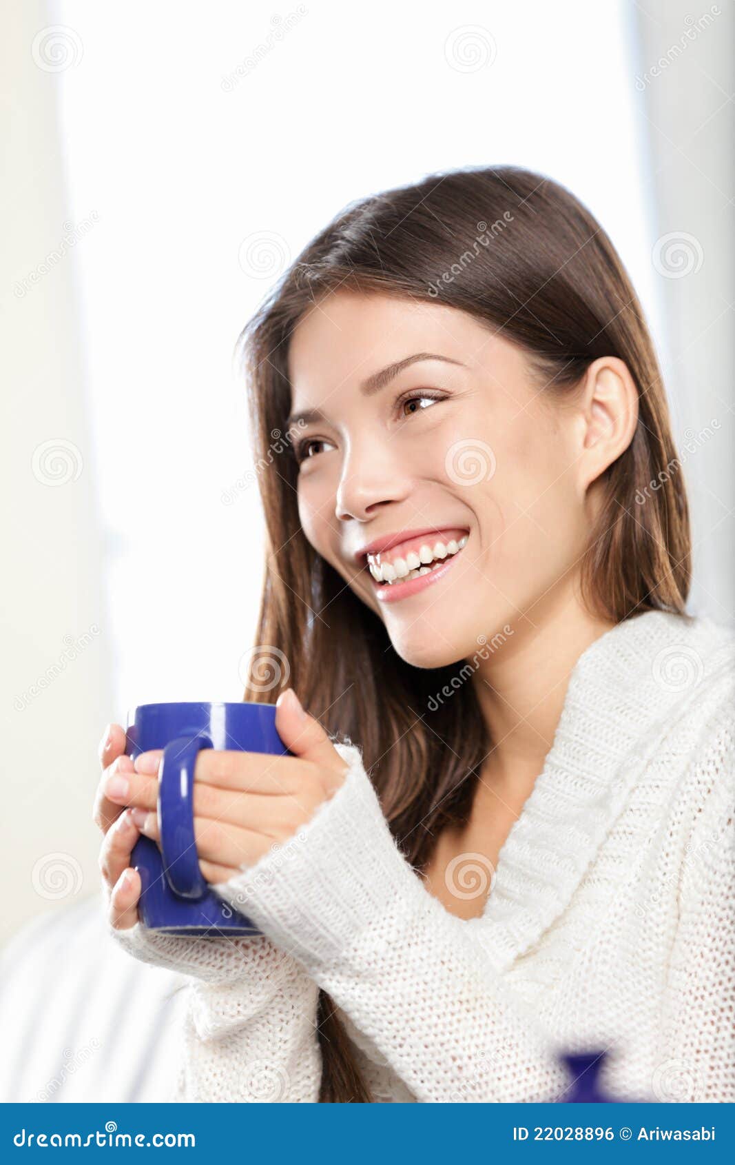 Het drinken van de vrouw thee. De zitting van de vrouw het drinken thee of koffie gelukkig glimlachen. Mooi gemengd ras Kaukasisch/Chinees Aziatisch vrouwelijk model thuis.