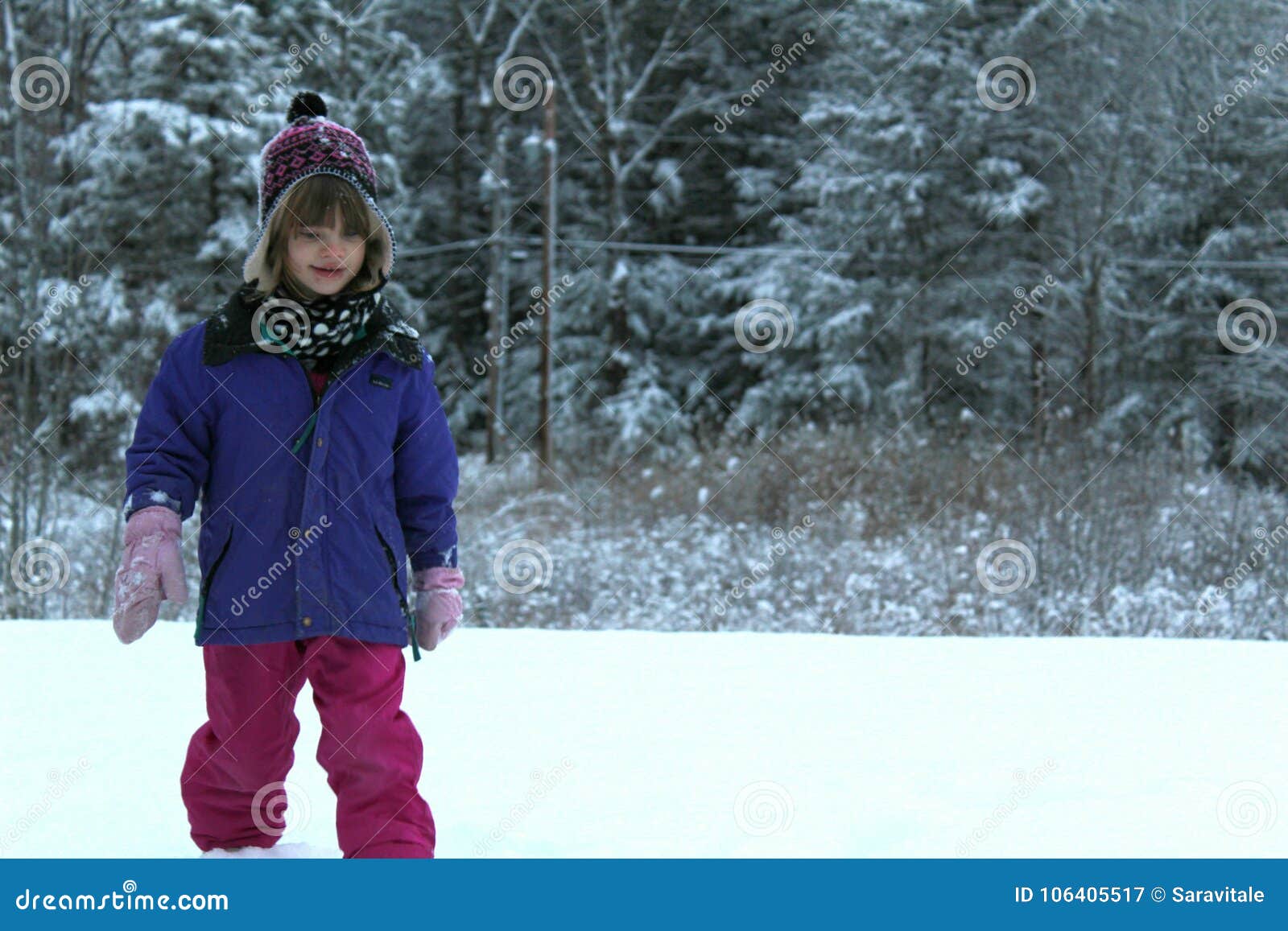 Het jonge meisje spelen in de sneeuw. Kind buiten in de winter