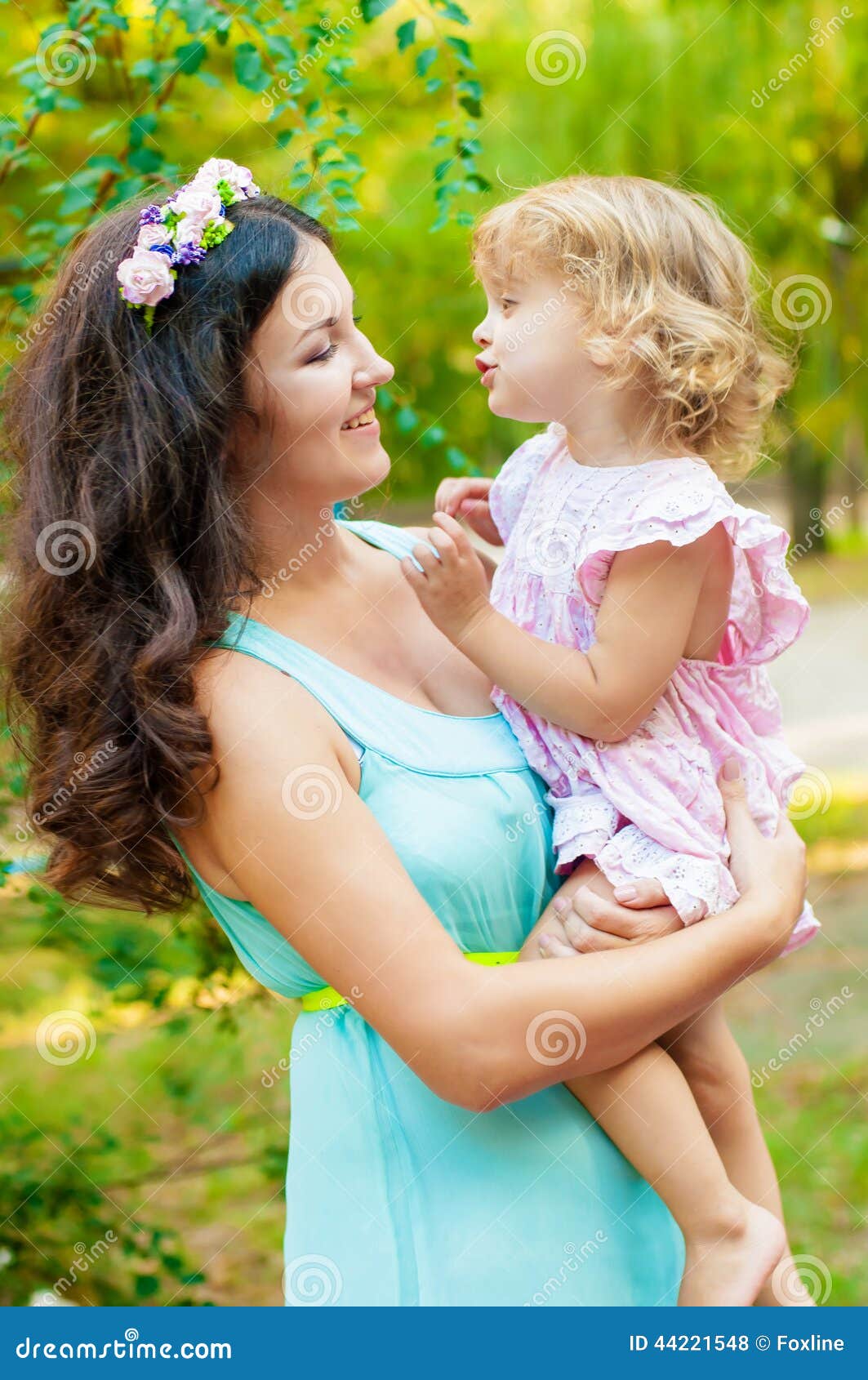 Het jonge moeder en meisje glimlachen. Jong moeder en meisje die in openlucht glimlachen