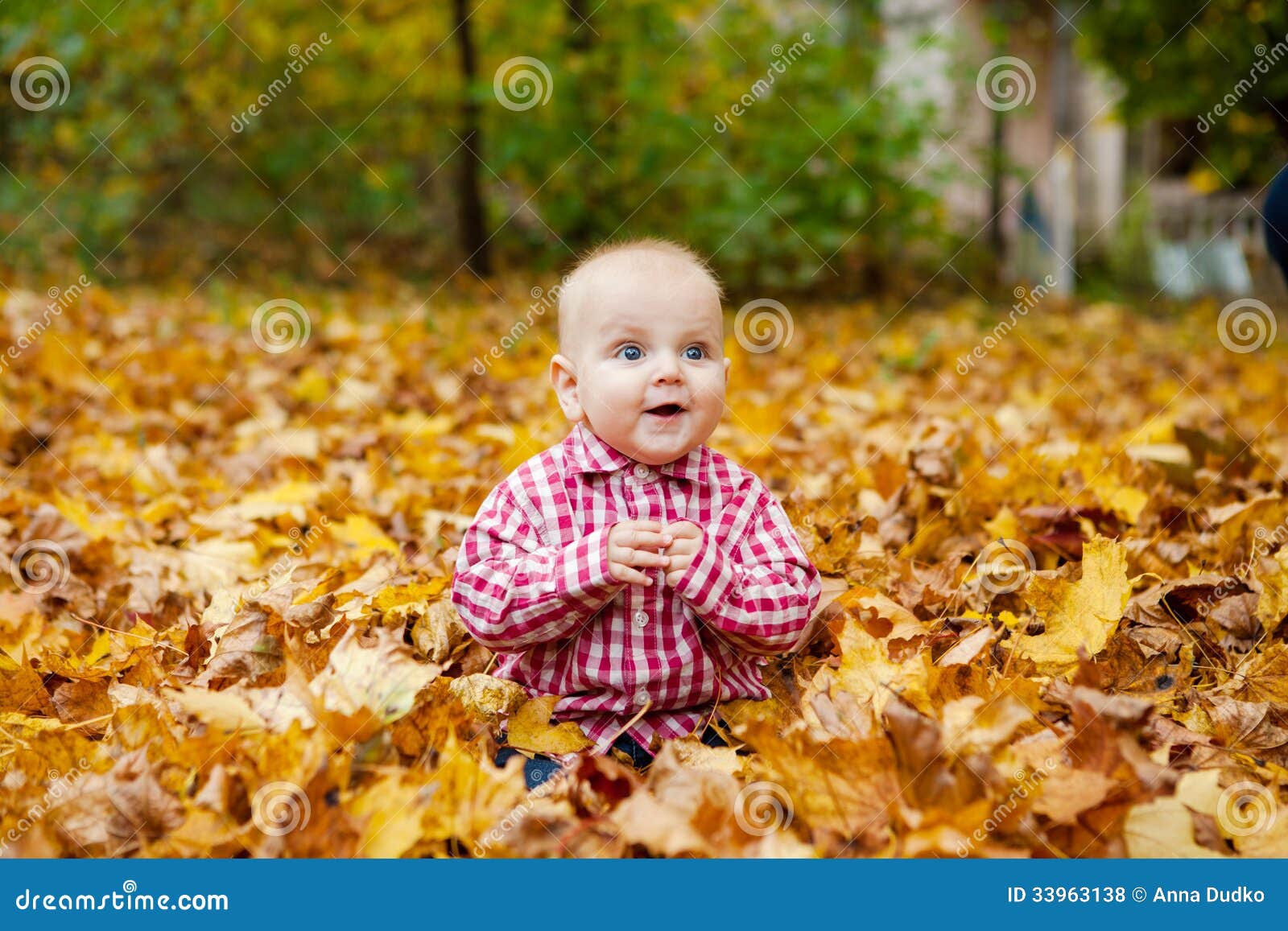 Het kind in rood overhemd zit in de herfstpark. Het kind in rood overhemd zit in de leuke baby van het de herfstpark