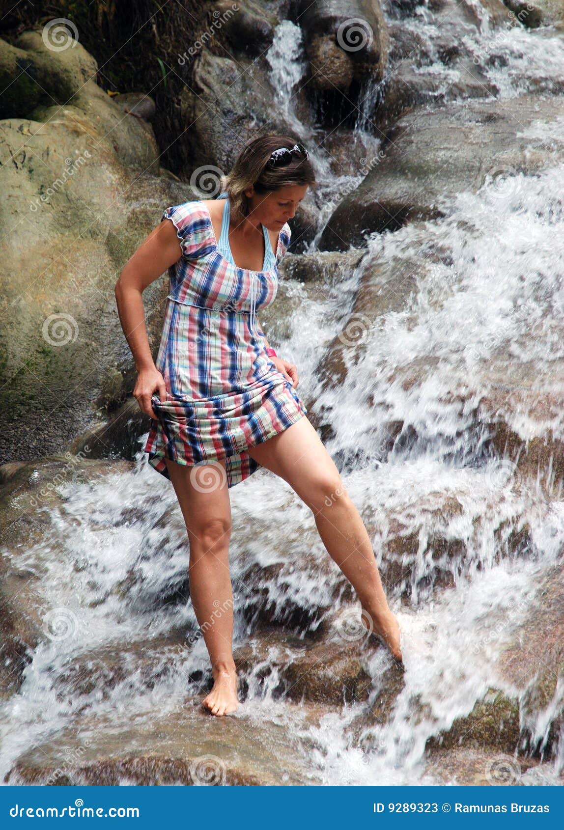 Het lopen in Jamaicaanse Dalingen. Het meisje dat haar voeten in de rivier van Dunn wast valt (Ocho Rios, Jamaïca).