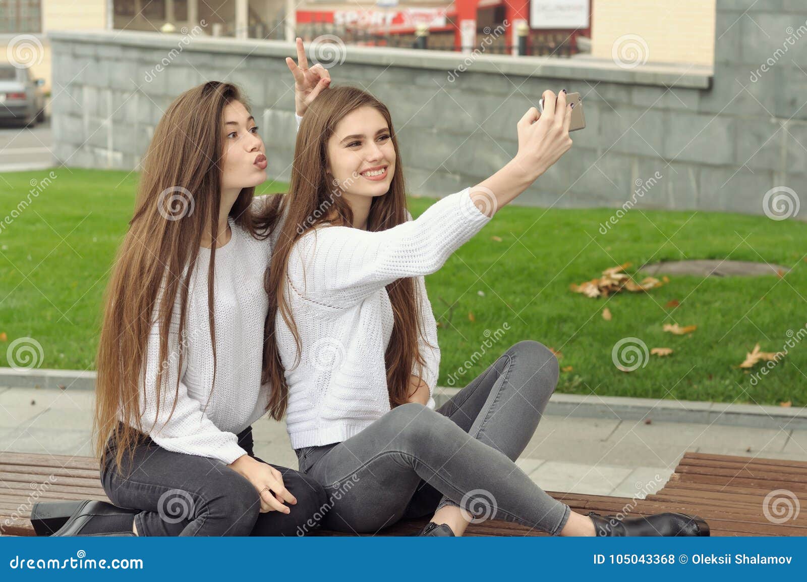 Пока подружка не видит. Девушка показывает рожки. Подруга поставила рожки. Обе фотографии. Женщина показывает рожки подруге.