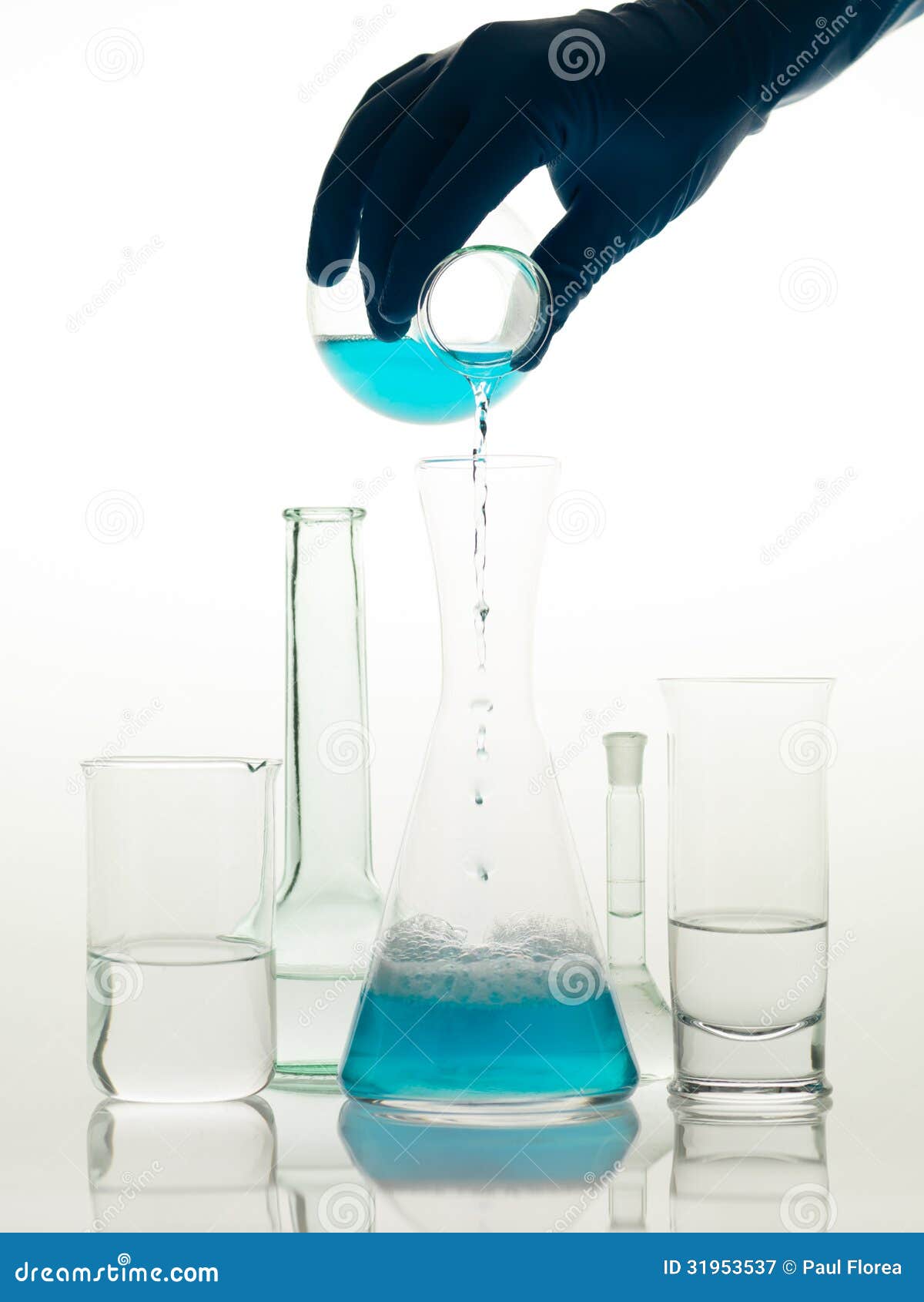 Het mengen van substanties in het laboratorium. Frontale mening van verschillende die types van glascontainers in het laboratorium worden gebruikt, met transparante kleurloze vloeistof en wordt gevuld waarin iemand een blauwe vloeistof giet
