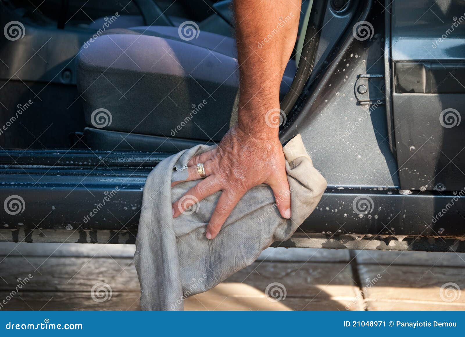 Het schoonmaken van de auto. Mens die en zijn auto thuis wast schoonmaakt