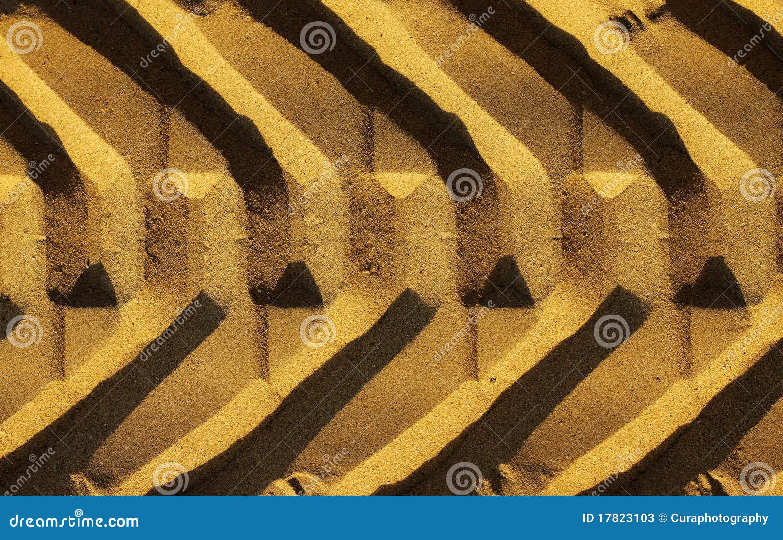 Het spoor van de band. Grafische foto van een breed bandspoor in gouden zand