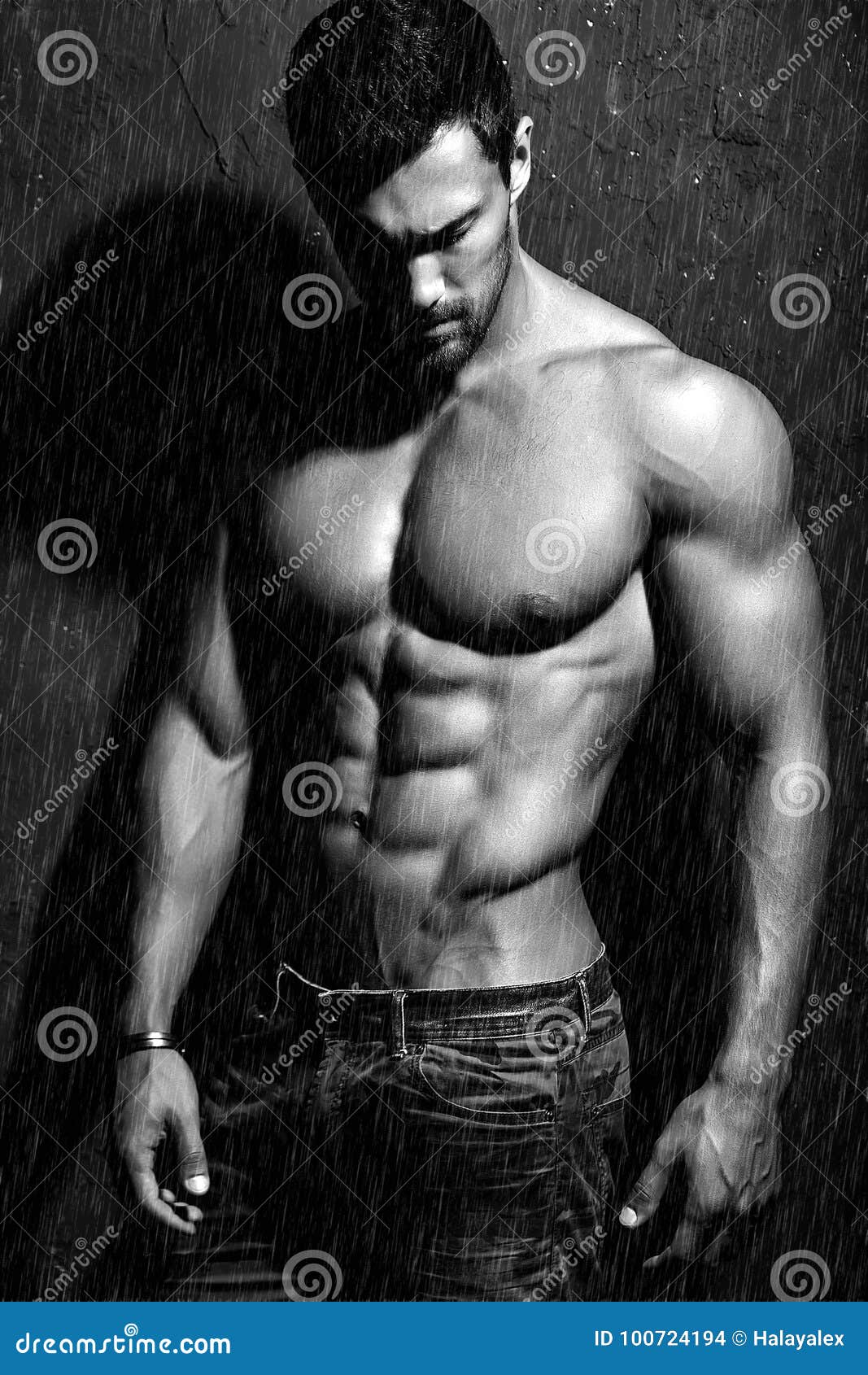 Portret van het sterke gezonde knappe Atletische Mensengeschiktheid Model stellen dichtbij donkergrijze muur in de regen