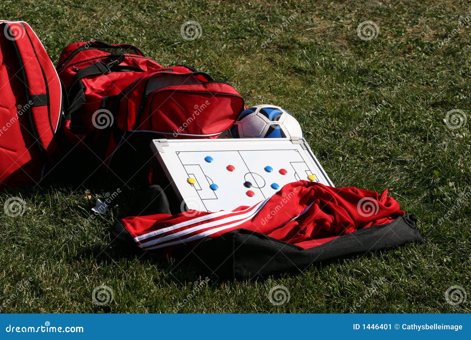 Het toestel van het voetbal. Rode duffel sportzak, jasje met voetbalbal en tactiekraad