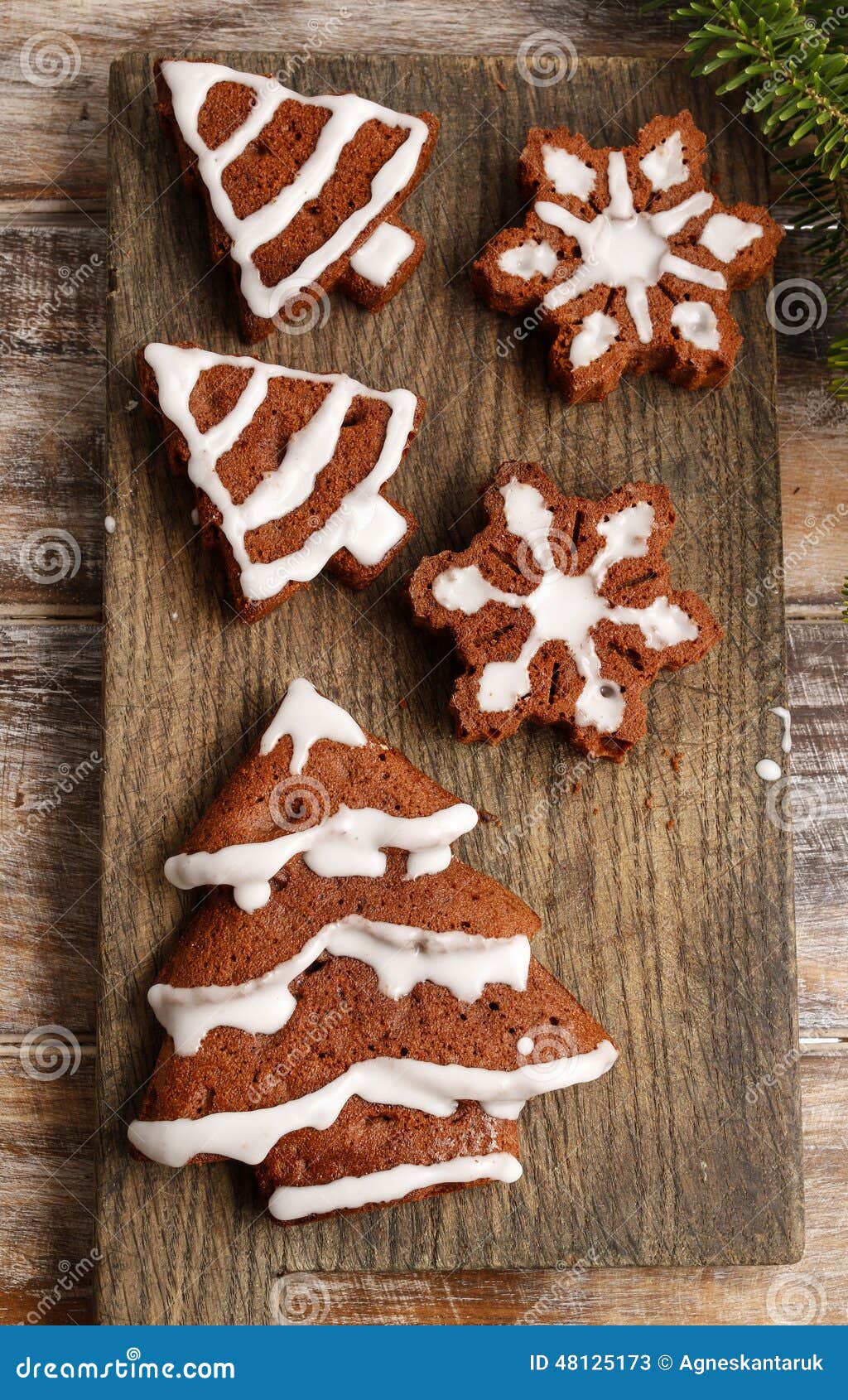 Het verfraaien van de chocoladekoekjes van de Kerstmispeperkoek met witte ic. Het verfraaien van de chocoladekoekjes van de Kerstmispeperkoek met wit suikerglazuur Feestelijk Dessert