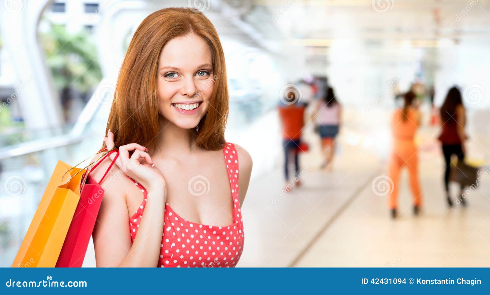 Mooie jonge vrouw met het winkelen zakken in een supermarkt