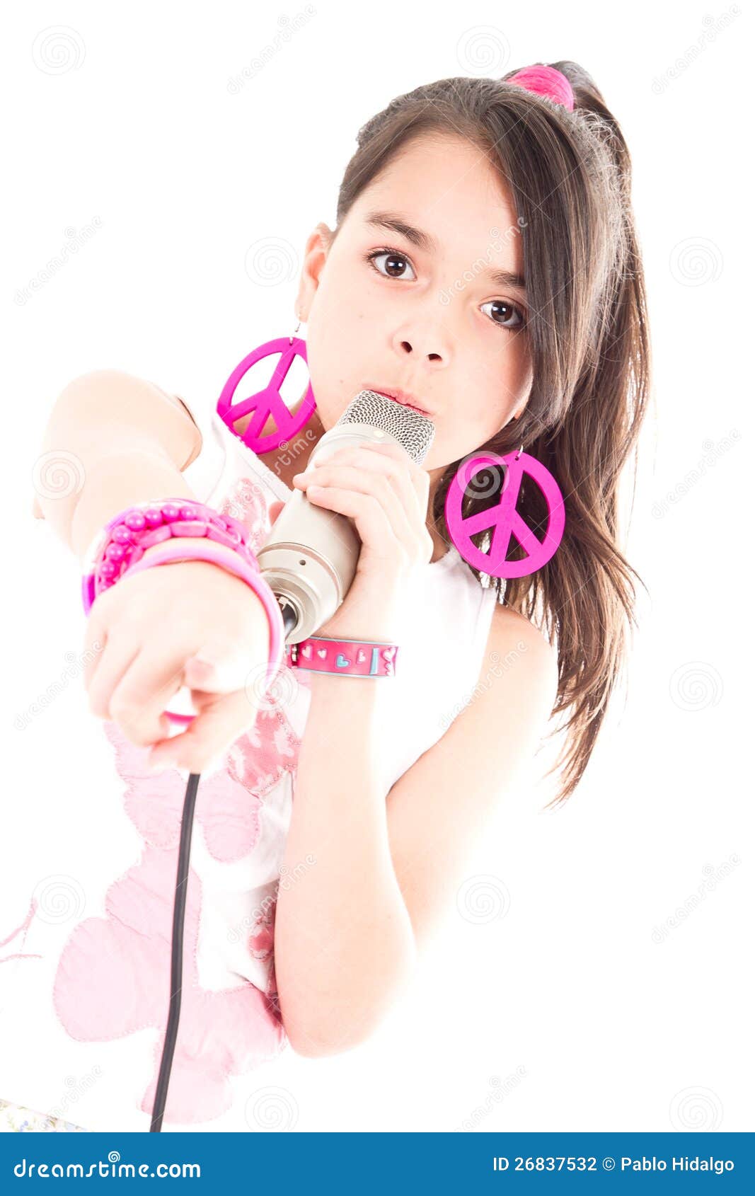 Het zingen van het meisje met microfoon die op u richt. Portret van meisje zingen met microfoon geïsoleerdd op witte achtergrond