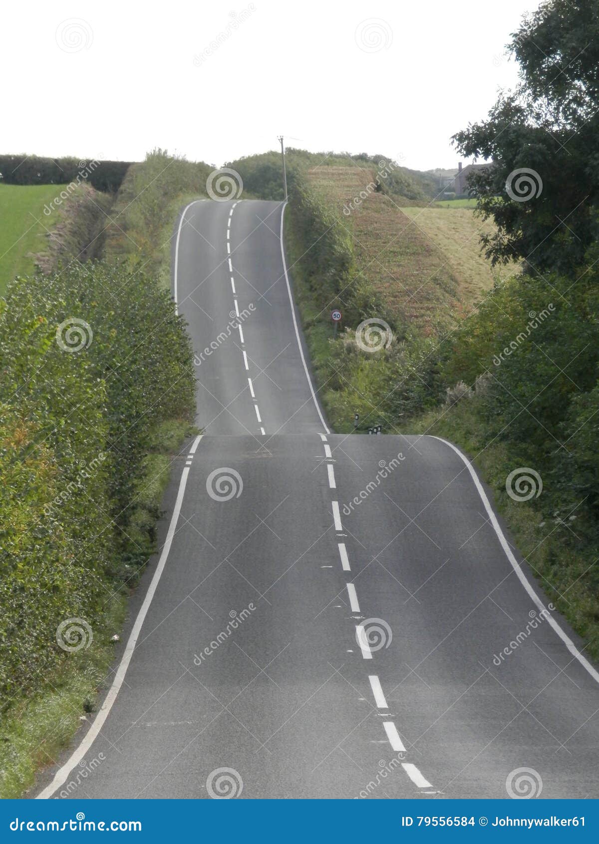 Heuvelige landweg die door het platteland van Dorset, het UK winden