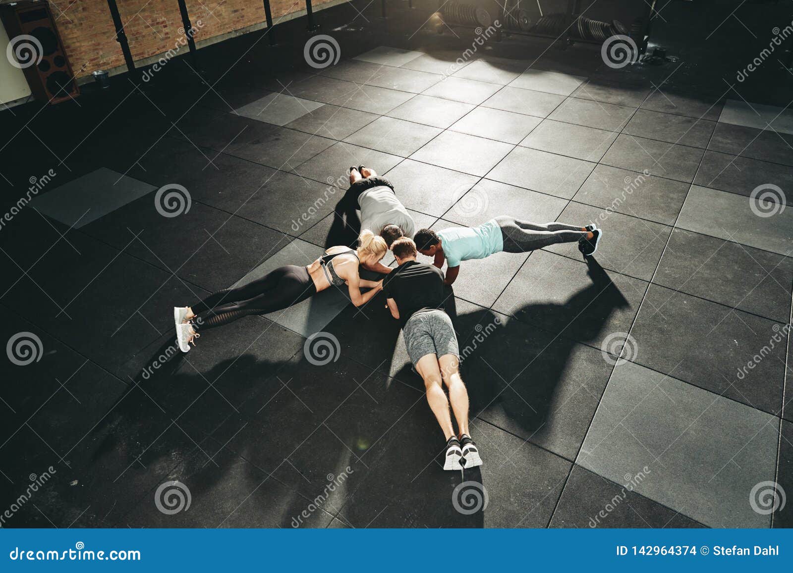 fit people planking together on a gym floor