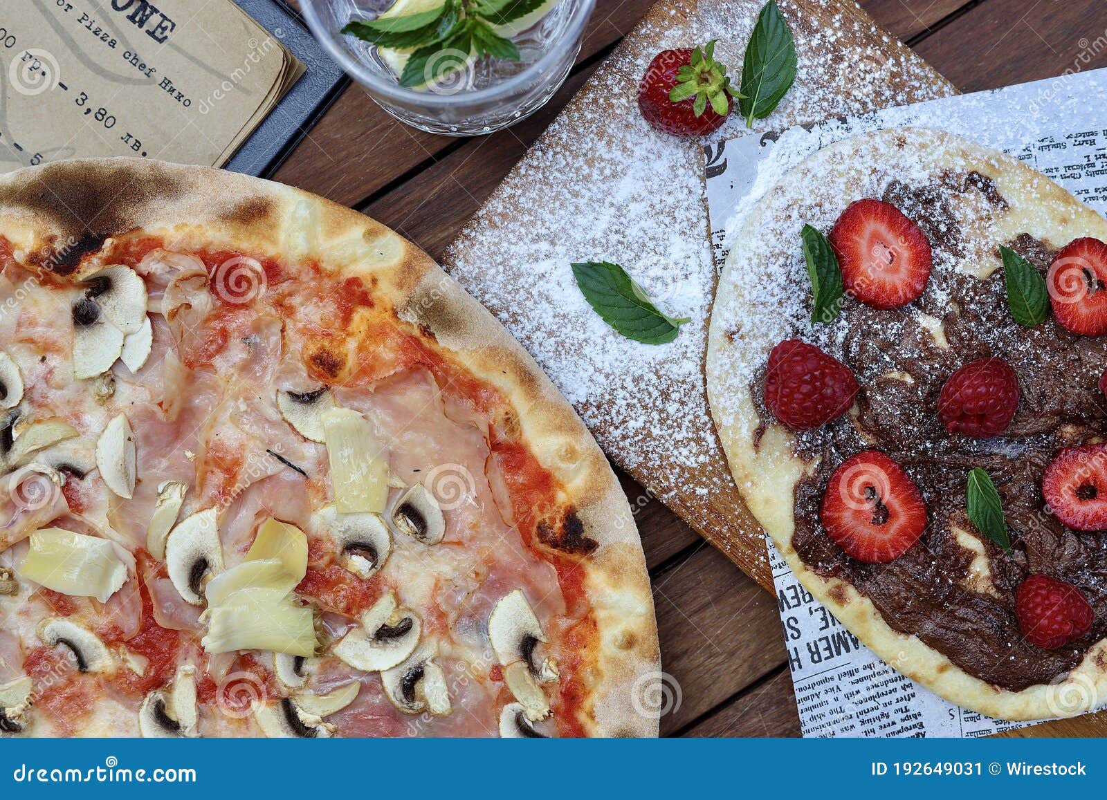 High Angle Shot of Delicious Pizza and Dessert on a Table Stock Image