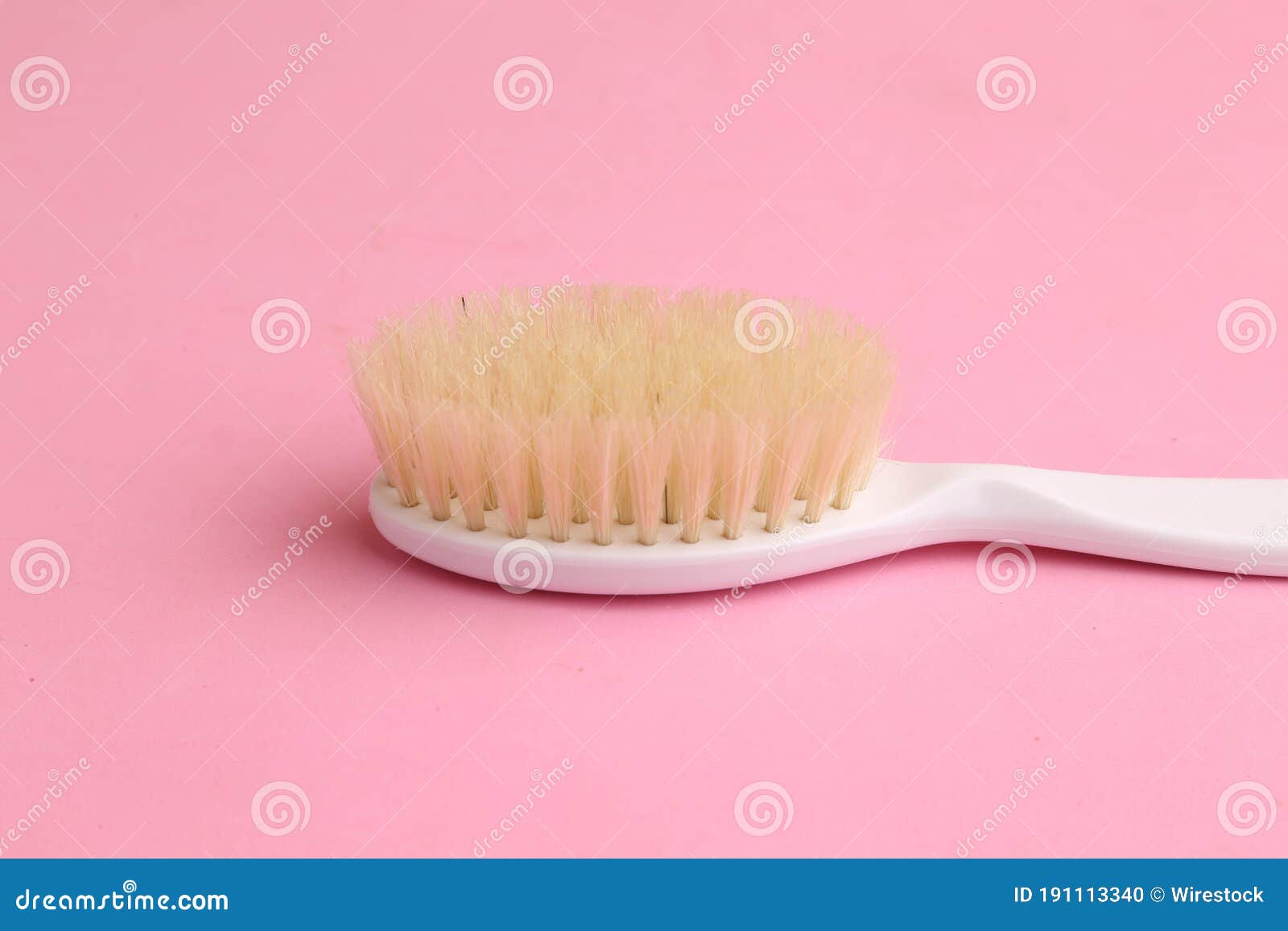 High Angle Shot of a White Bathroom Brush Isolated on a Pink Surface