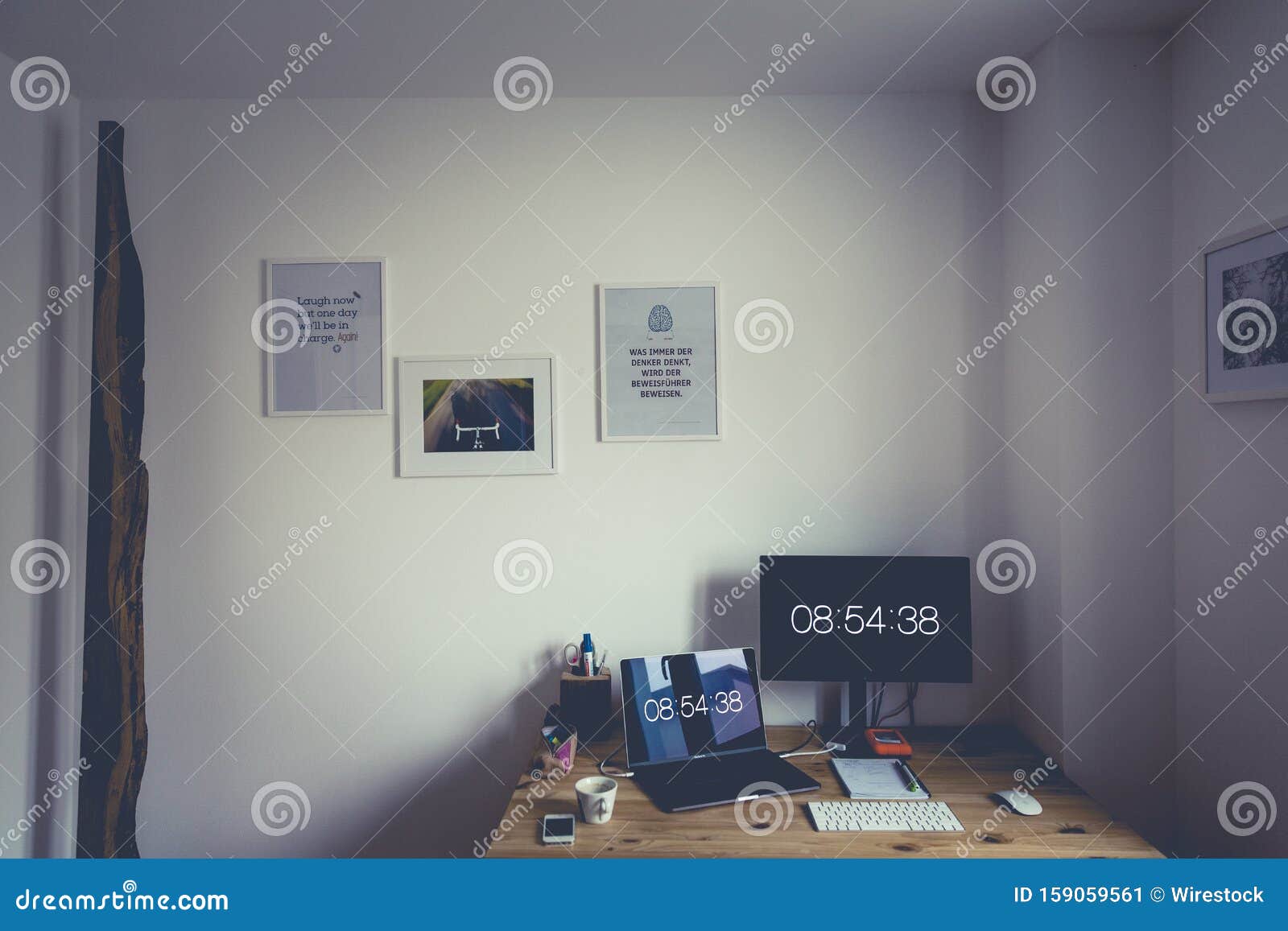 High Angle Shot Of A Desk With A Computer A Laptop And Posters