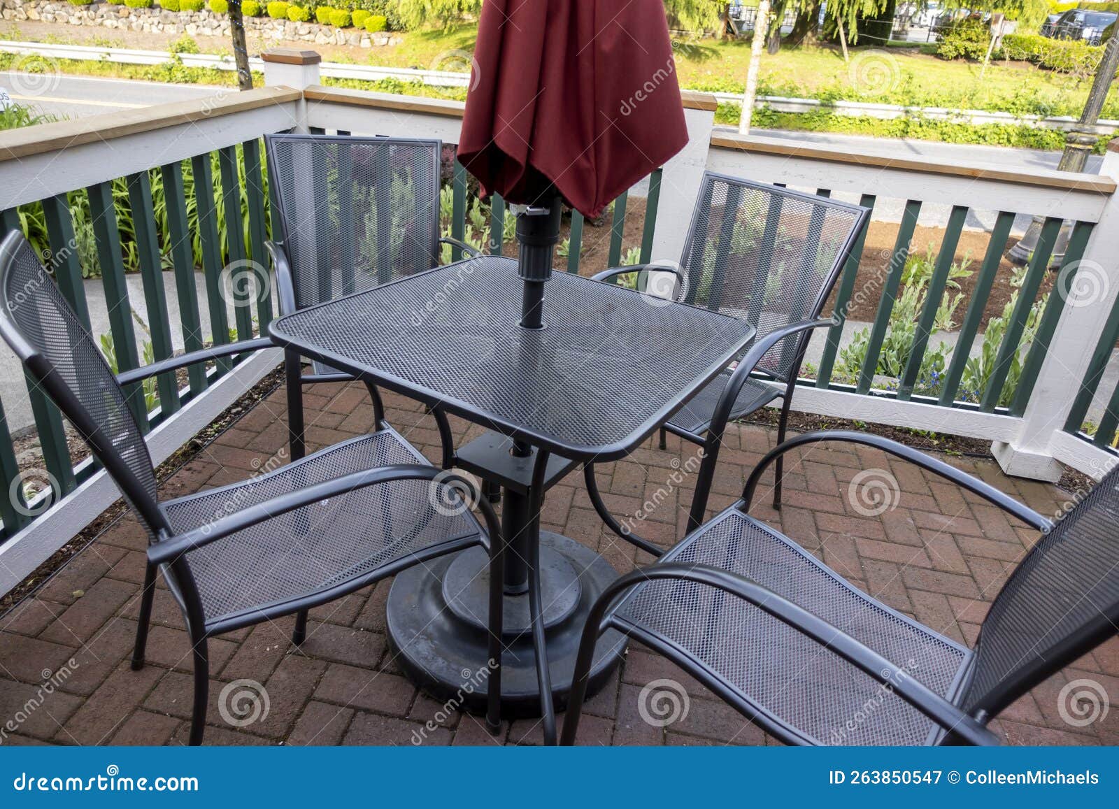 High Angle View of a Black Patio Table with Chairs and a Red Umbrella