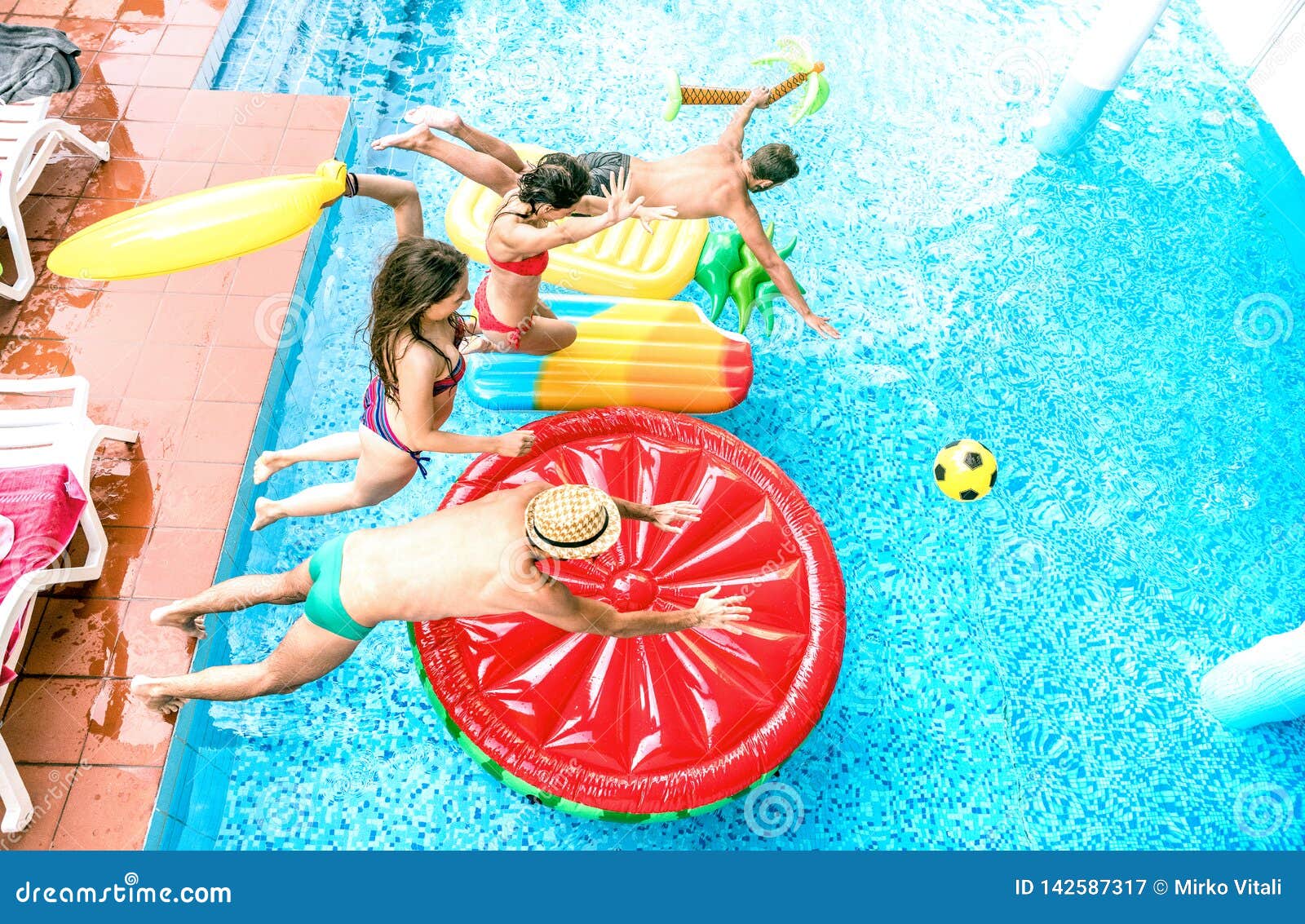 high angle view of millenial friends jumping at swimming pool party - youth vacation concept with happy guys and girls having fun