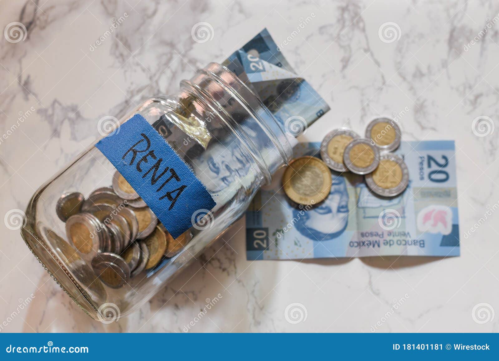 high angle view of pesos and coins in a jar with a blue [renta-rent] sticker on it on the table