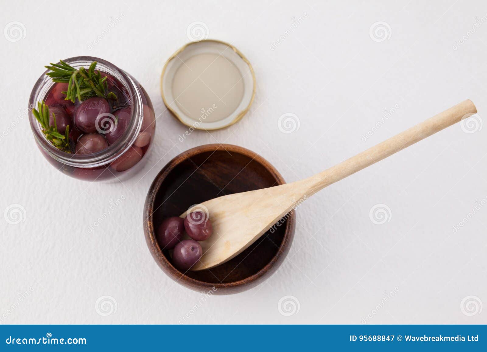 High Angle View of Red Olives in Jar and Container with Wooden Spoon