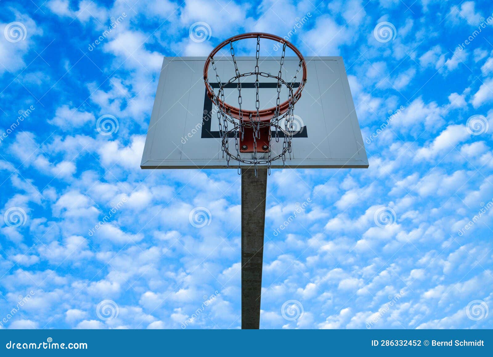 High Basketball Hoop with Blue Sky and Clouds Scenery Stock Photo