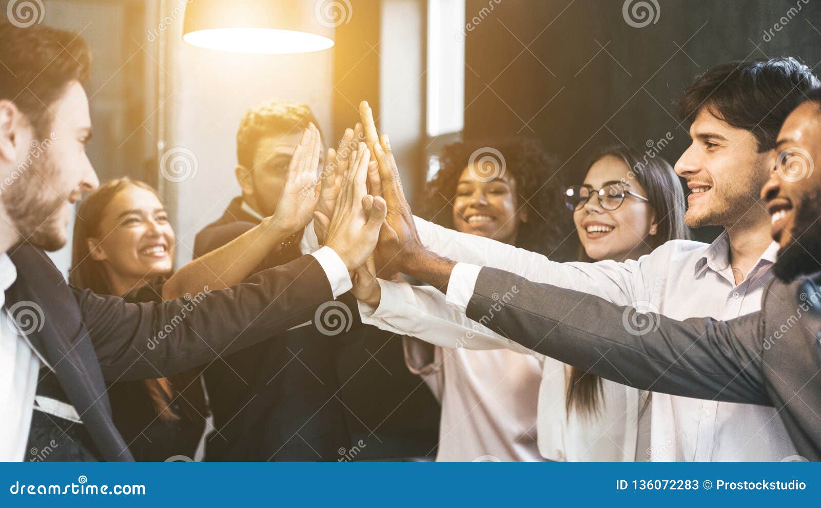 high-five for success. diverse group of business colleagues in office