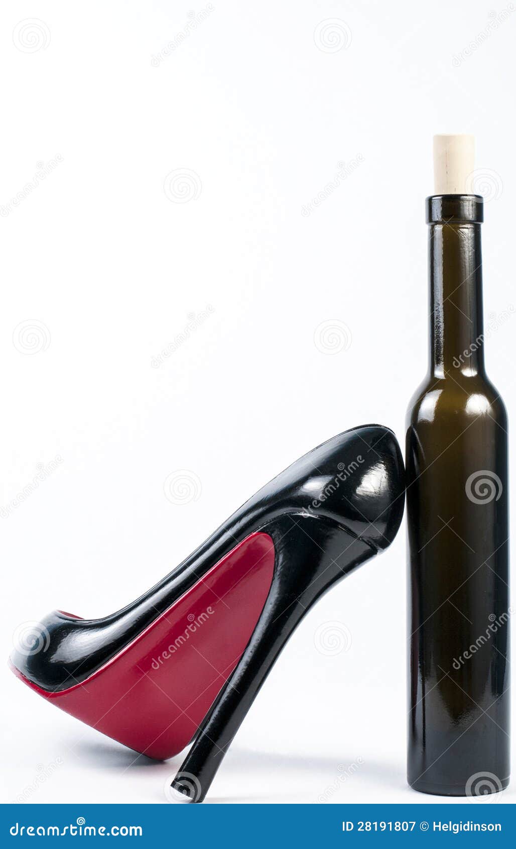 Human leg with high heels and stocking on table, wine glasses in background  stock photo