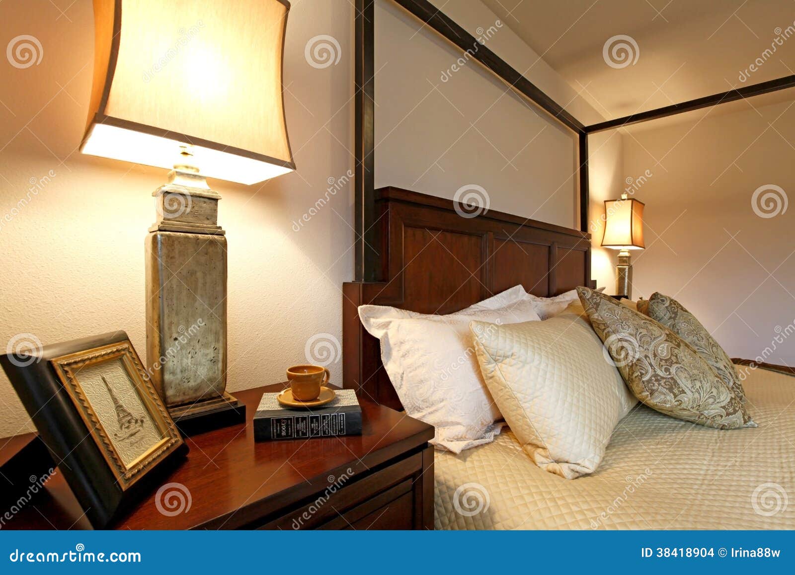 High Posts Bed with a Beautiful Beige Bedding and Nightstand. Cl Stock