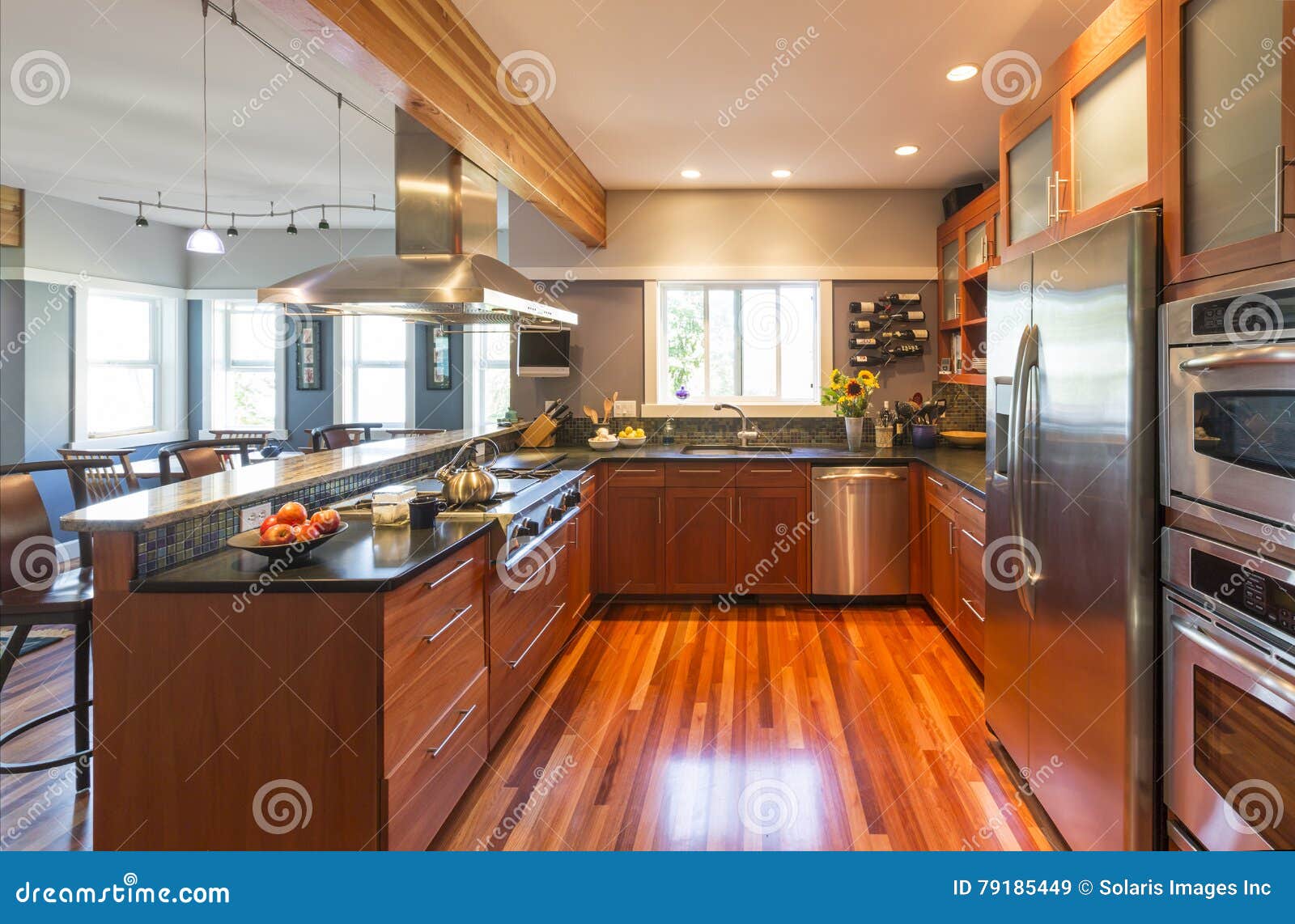 high quality contemporary home kitchen with wood cabinets, hardwood floor, stainless steel appliances, windows and accent lighting