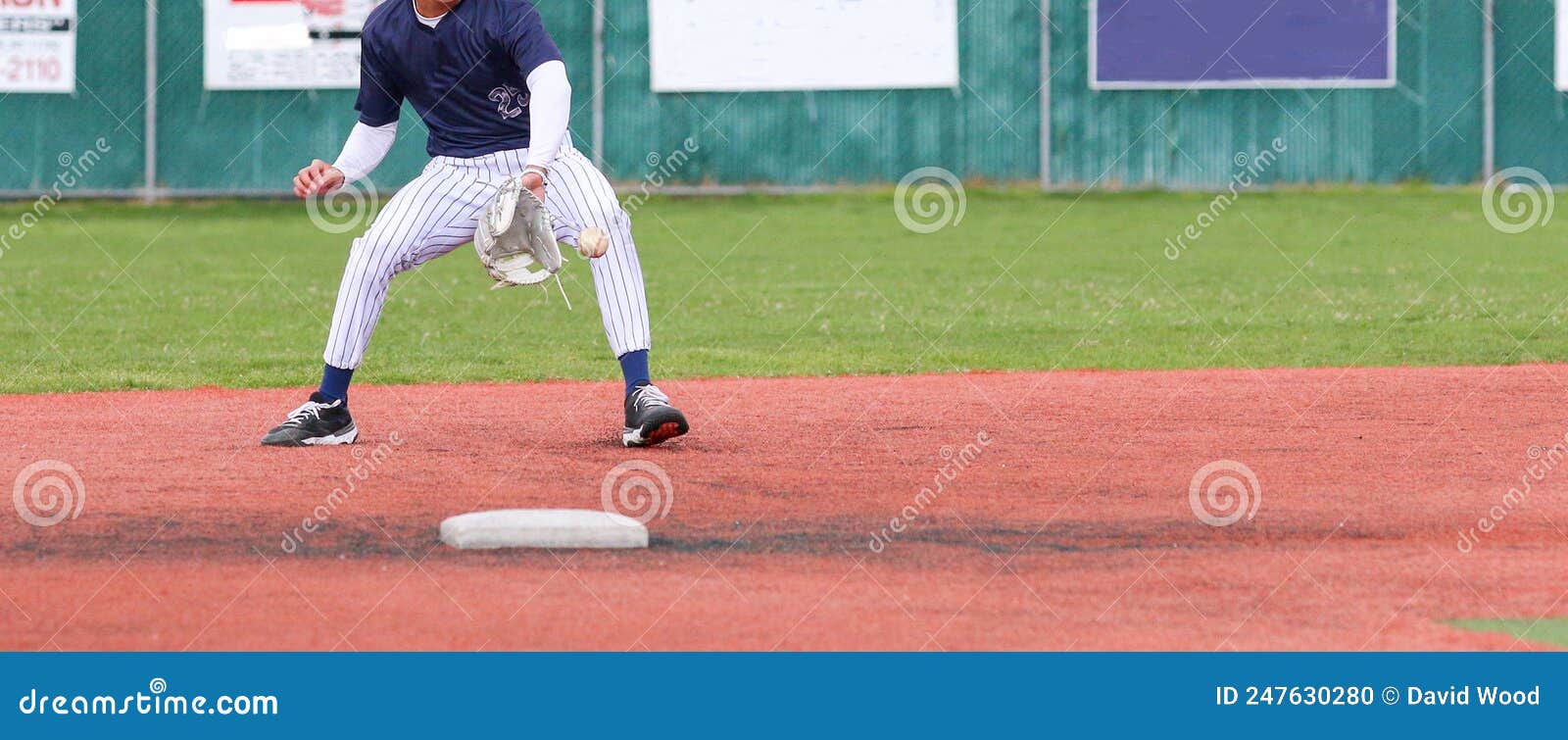 Baseball Second Baseman Backhanding a Ground Ball during a Game Stock