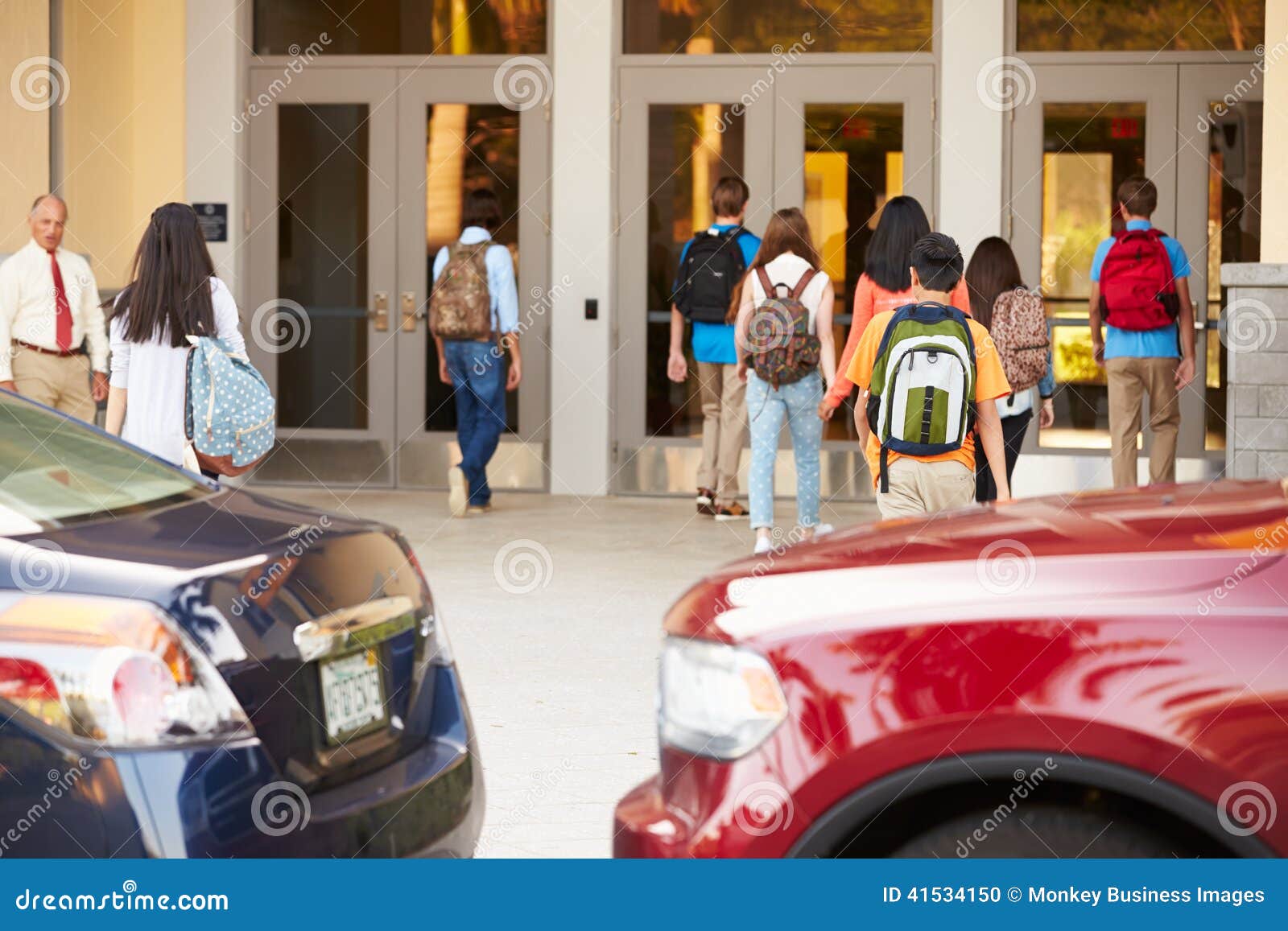 high school students being dropped off at school by parents