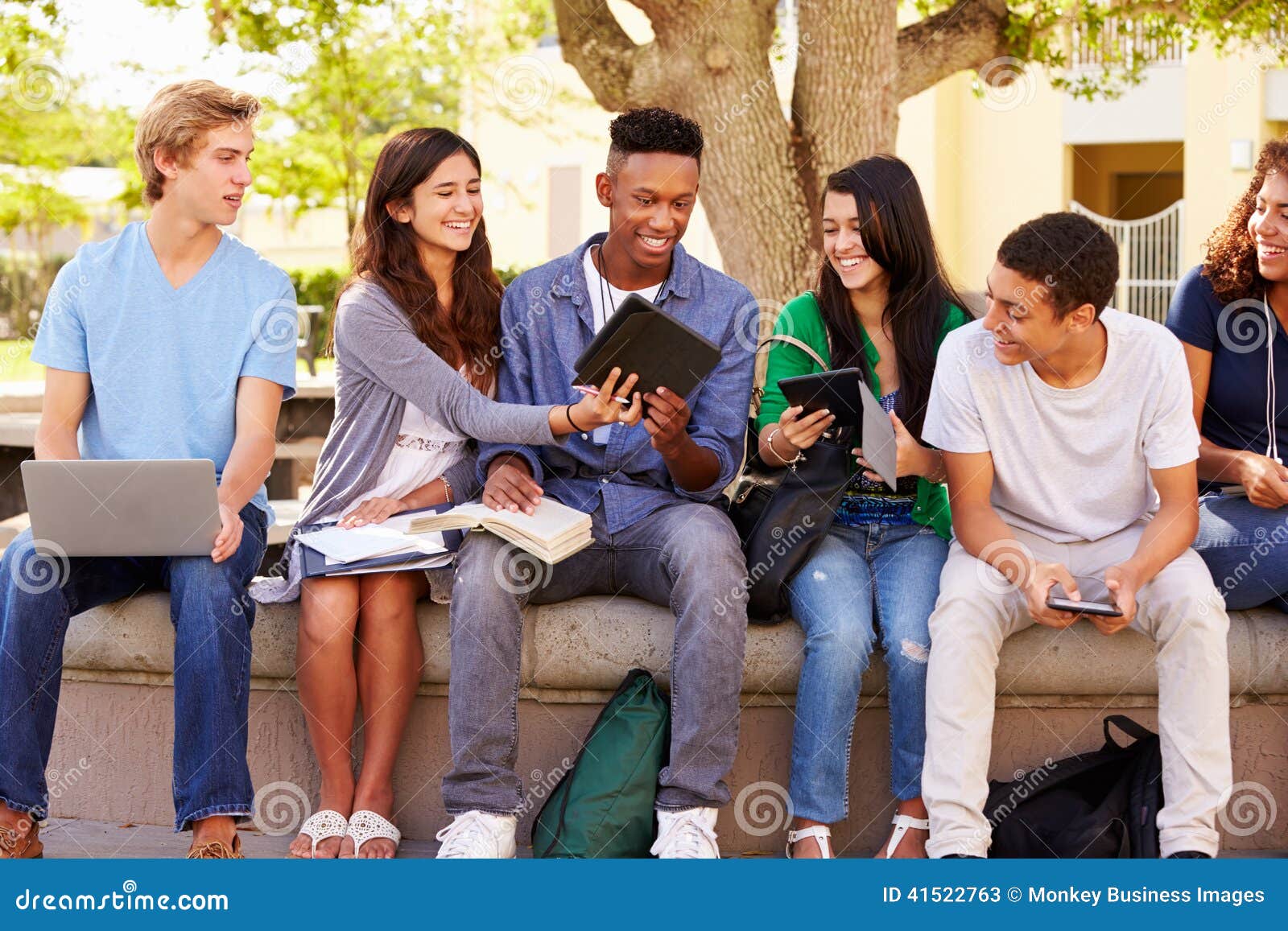 high school students collaborating on project on campus