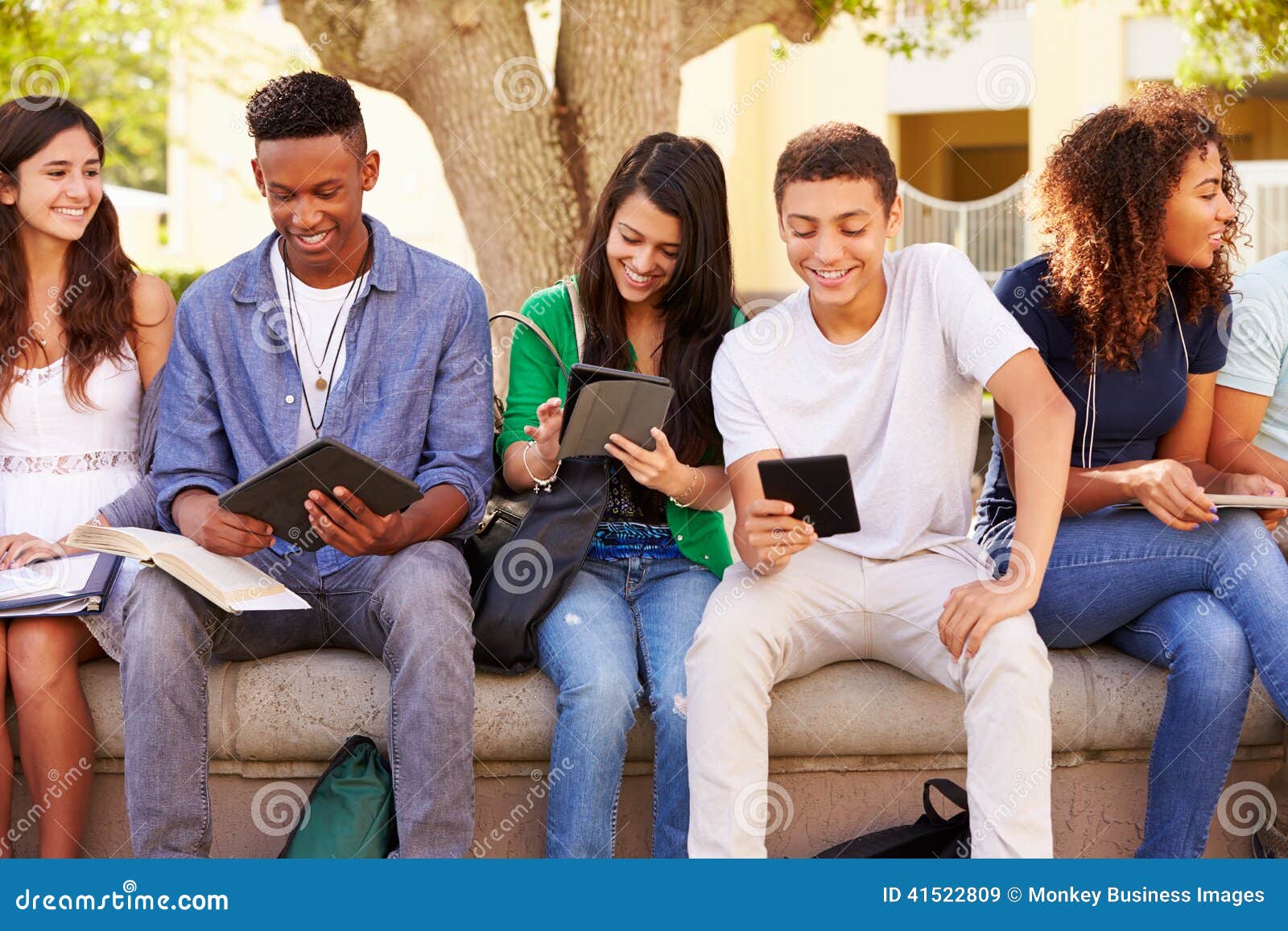 high school students collaborating on project on campus