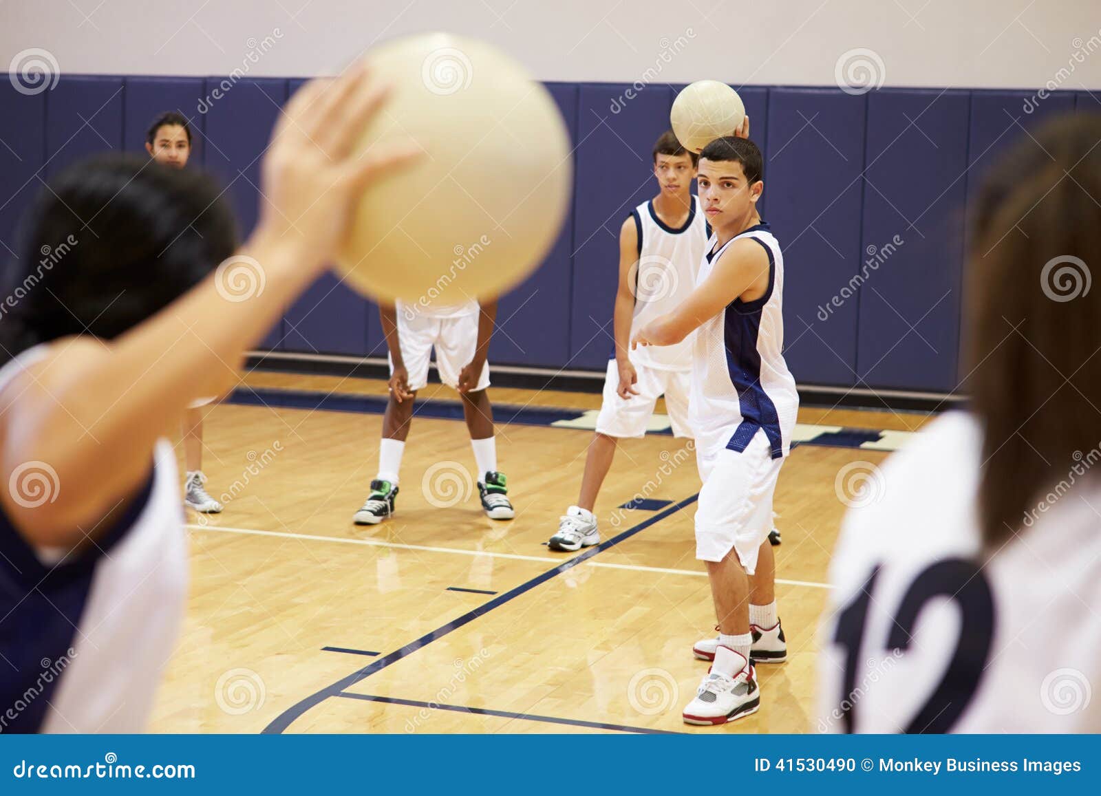 high school students playing dodge ball in gym