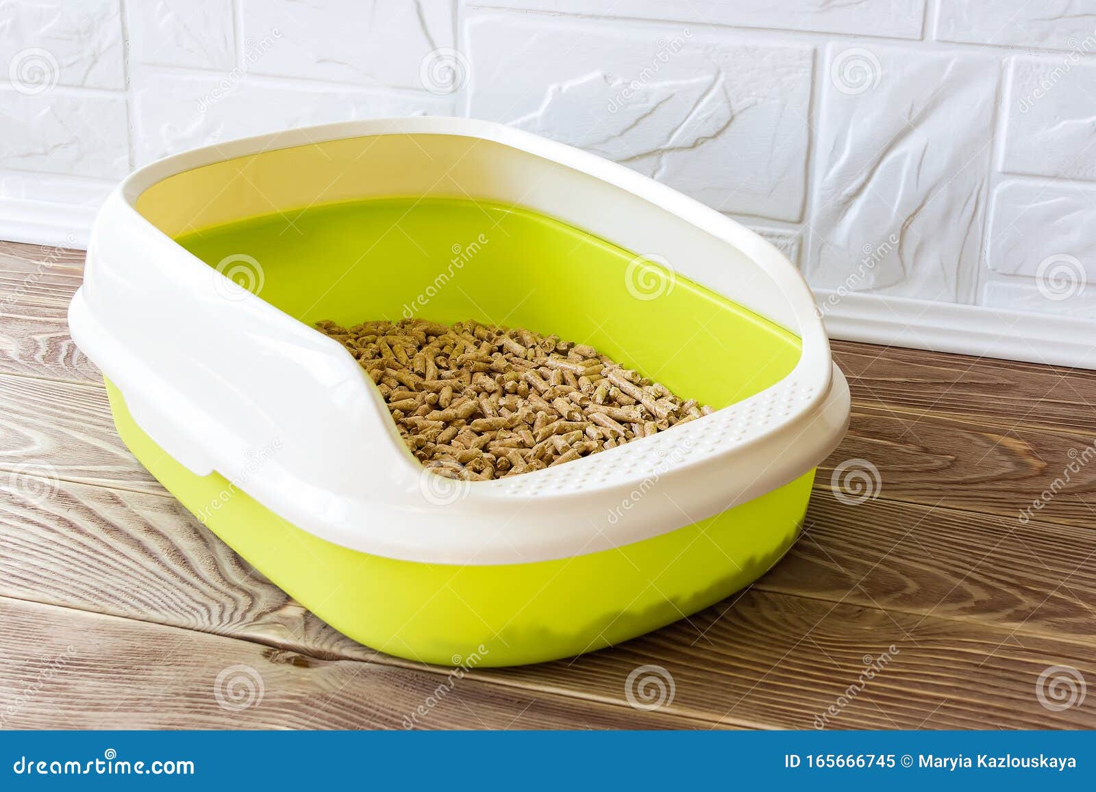 High Sided Cat Litter Tray With Wooden Pellets On A Brown Wooden Floor