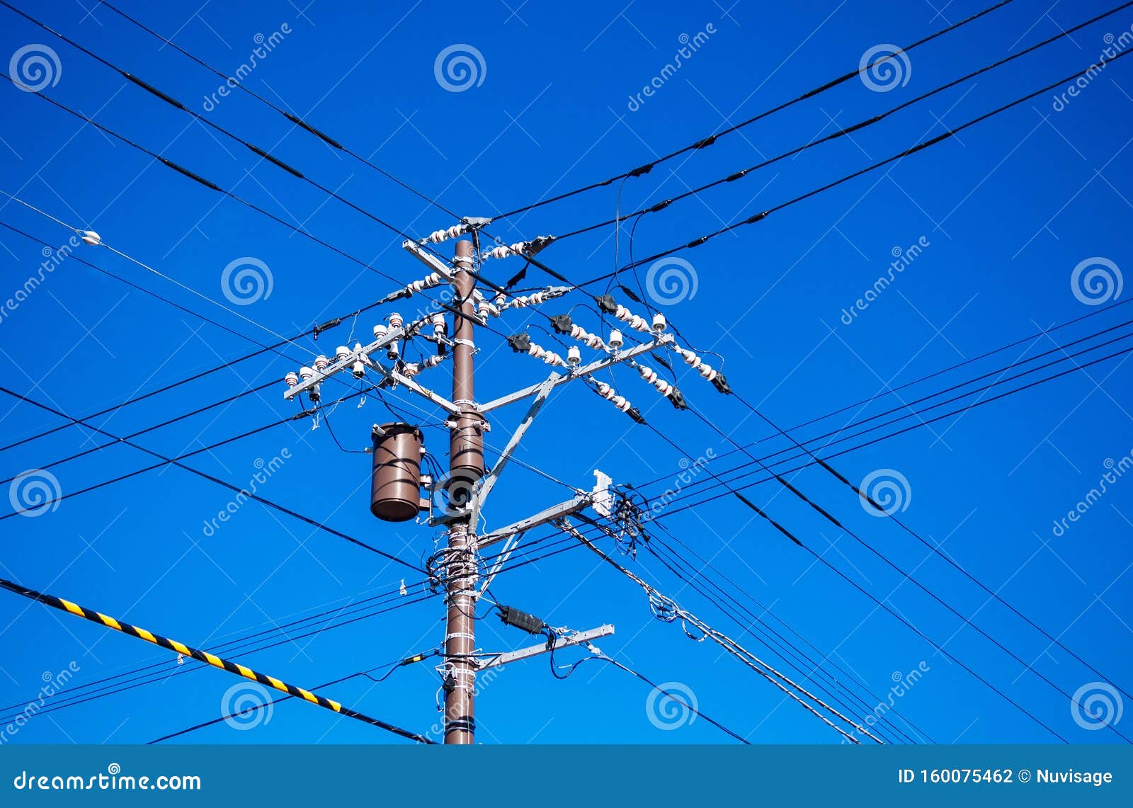 High Voltage Wires on Electric Pole with Transformer Against Sky Stock