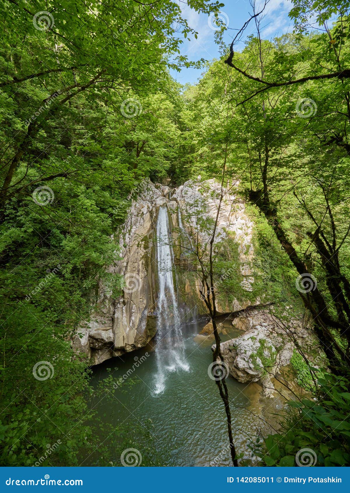 A High Waterfall Falls from a Cliff into a Clear Lake Stock Image ...