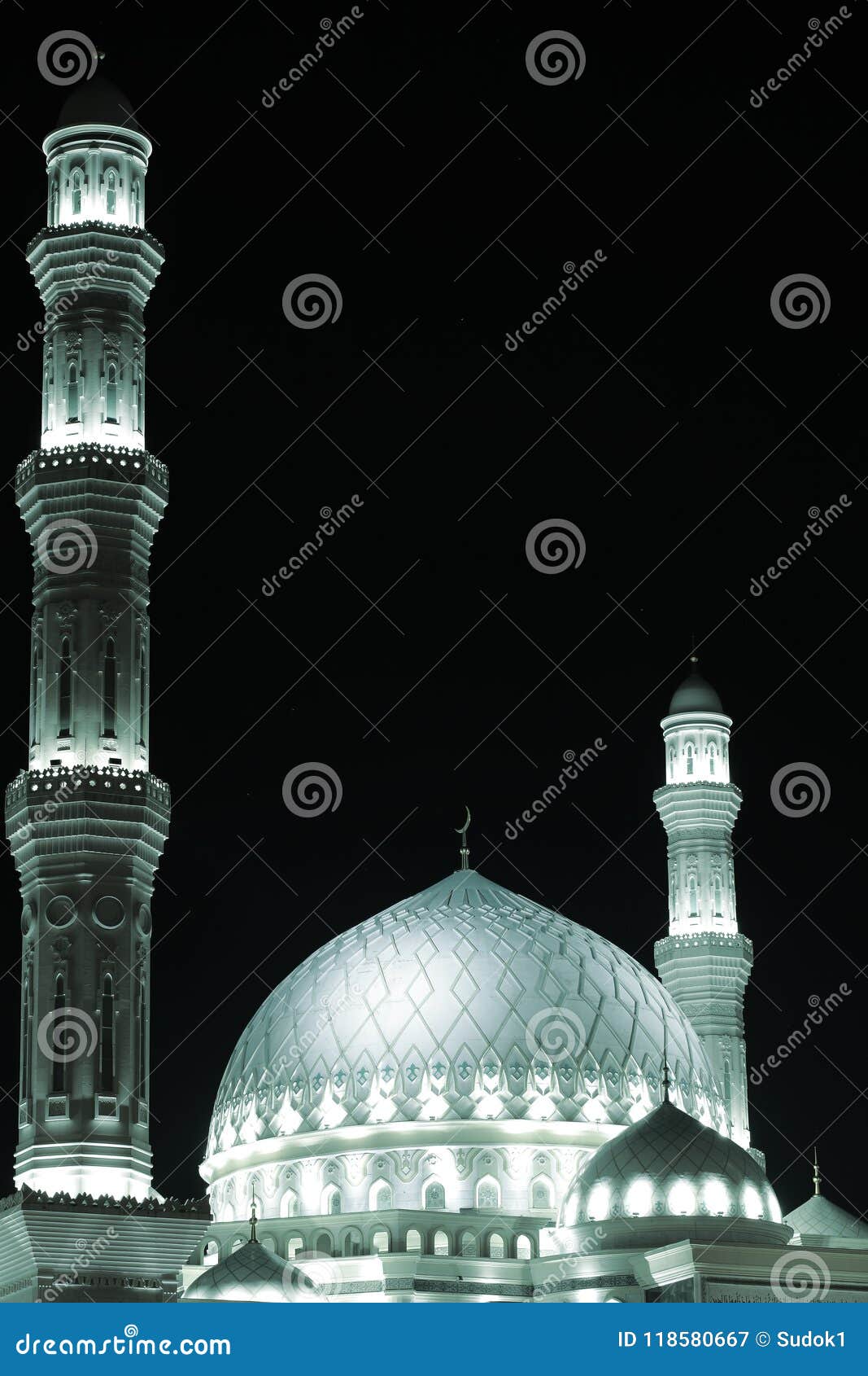 highlighted white dome and minarets of the mosque against the dark sky.