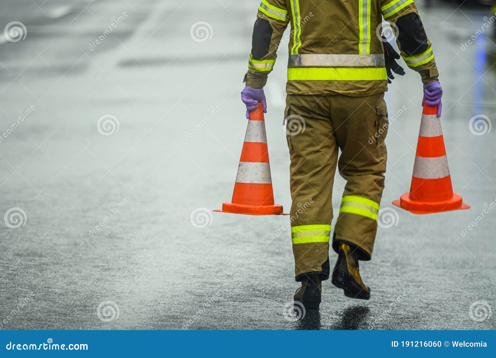 highway worker preparing for road closure moving two traffic cones