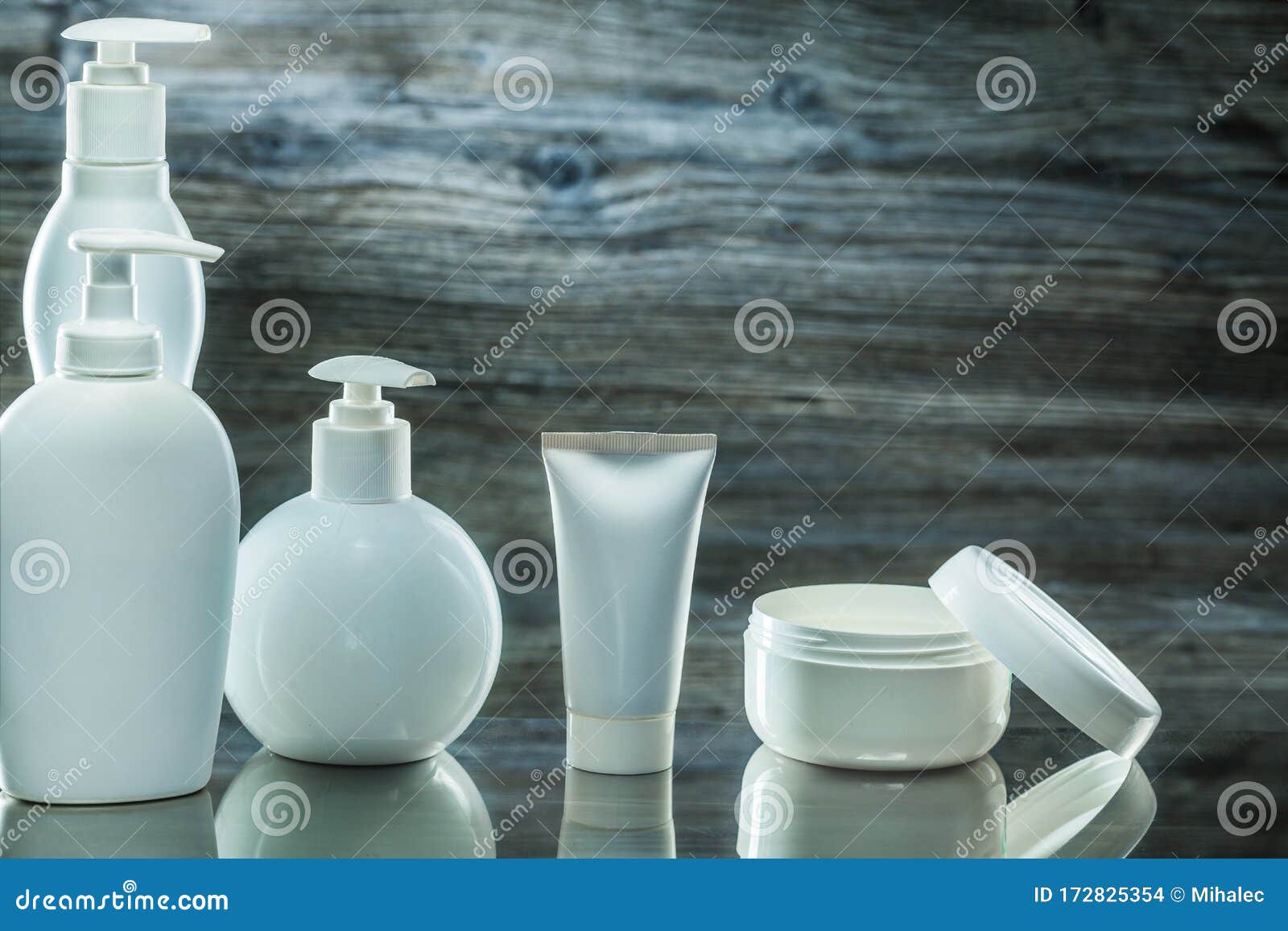 higiene products white plasic pump dispensers tube and jar cream on vintage wooden background