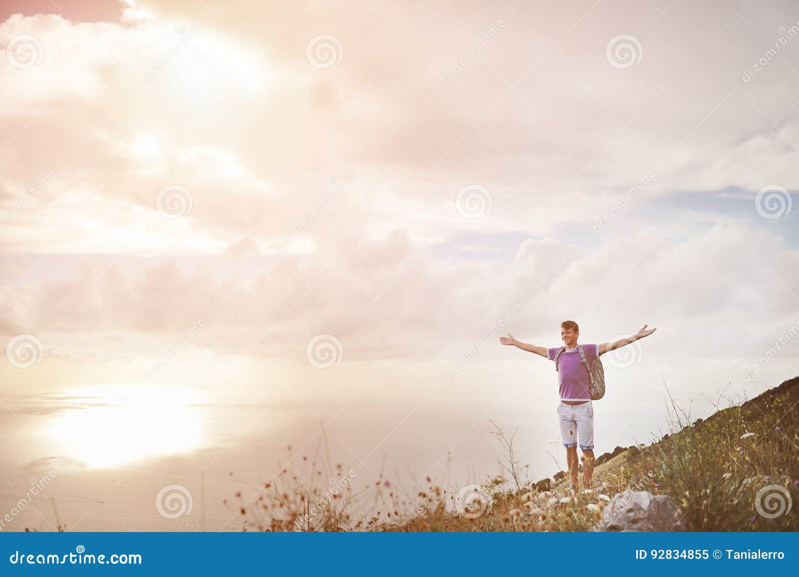 hiker with arms wide open on top of a mountain - freedom conquest concept