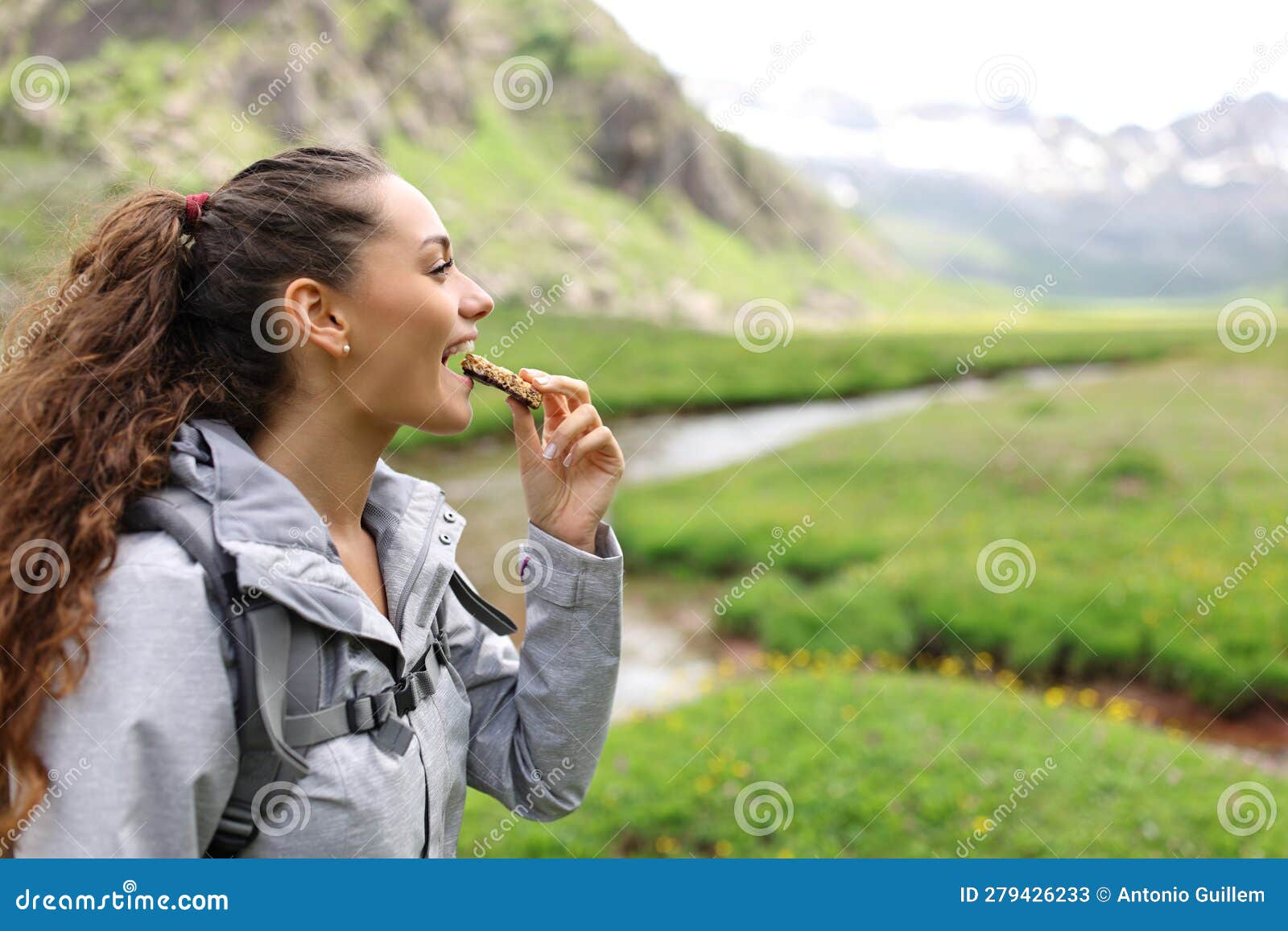 hiker eating cereal bar in a valley