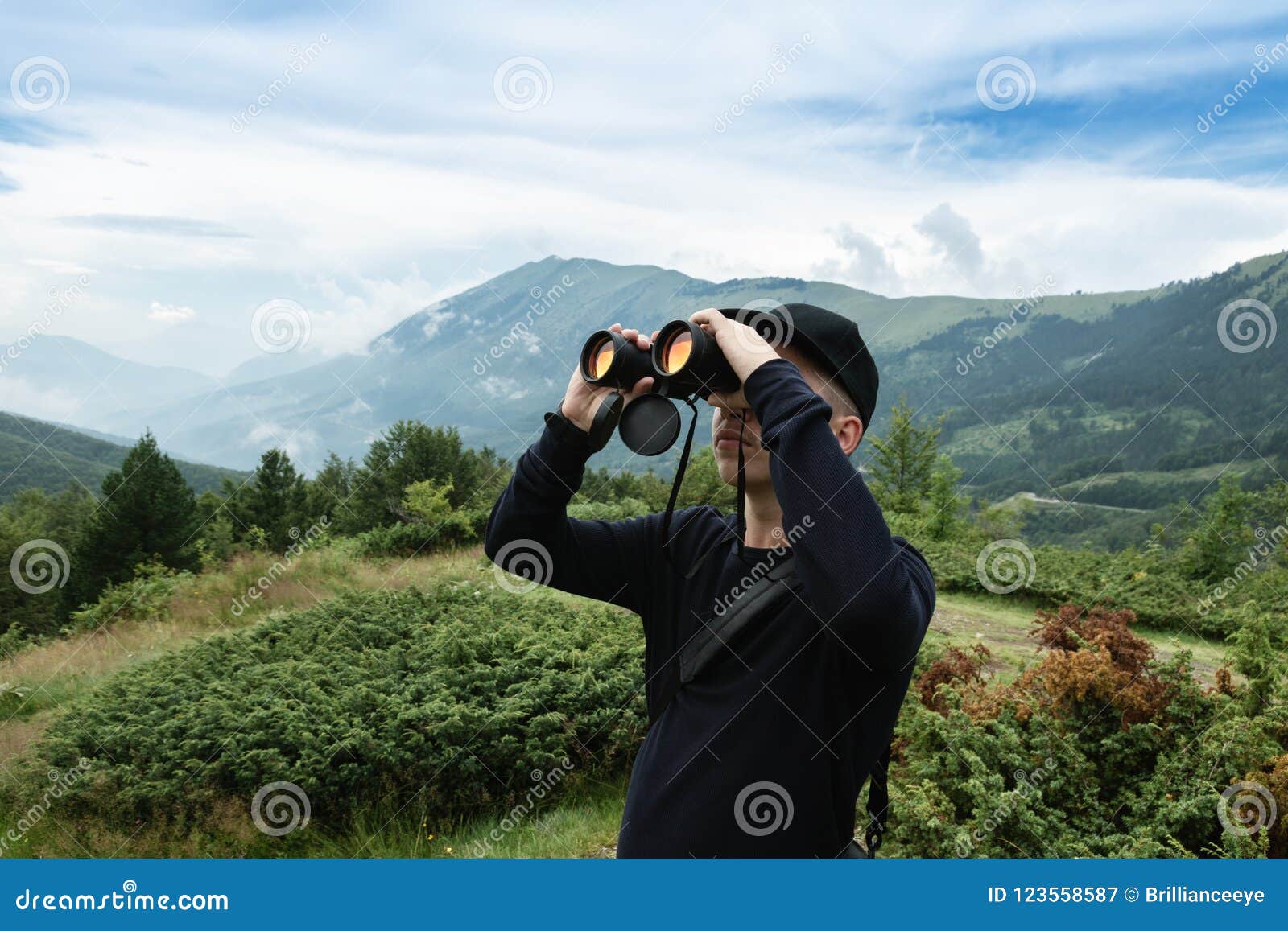 Hiker Looking through Binoculars in Front of Hills and Mountain Stock Image Image of