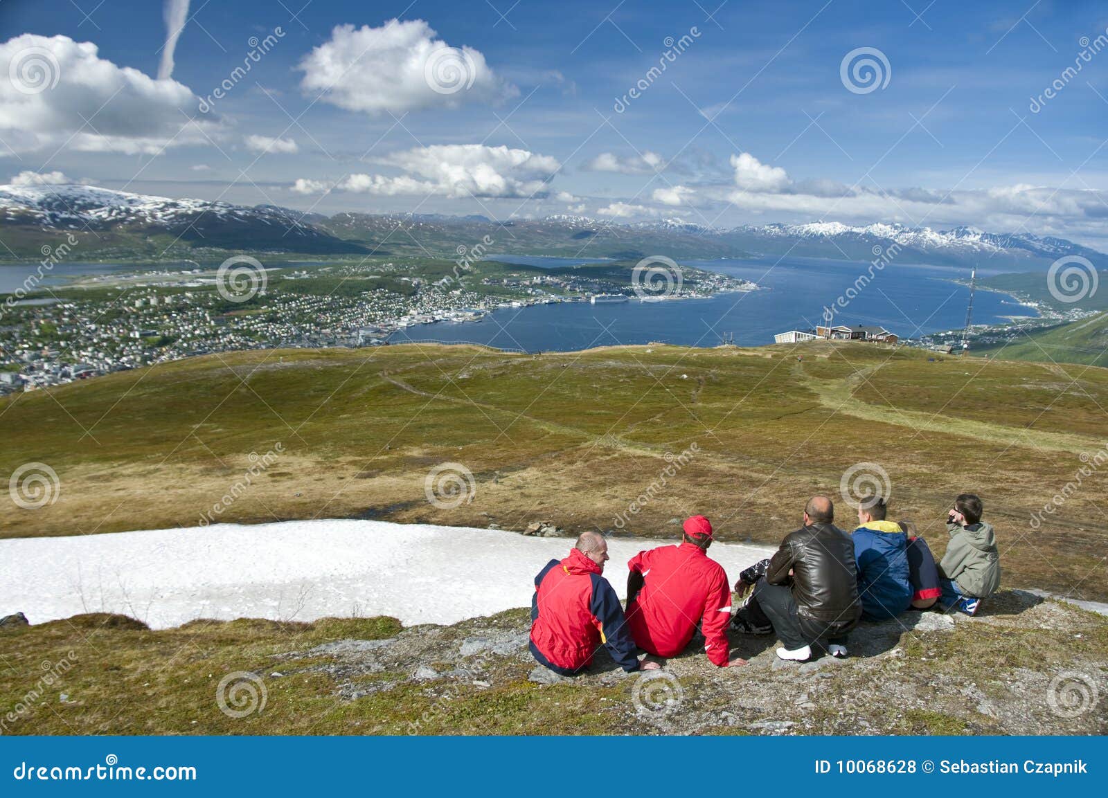 Hikers looking at Tromso city. Group of hikers on hillside viewing Tromso city in distance, Norway.