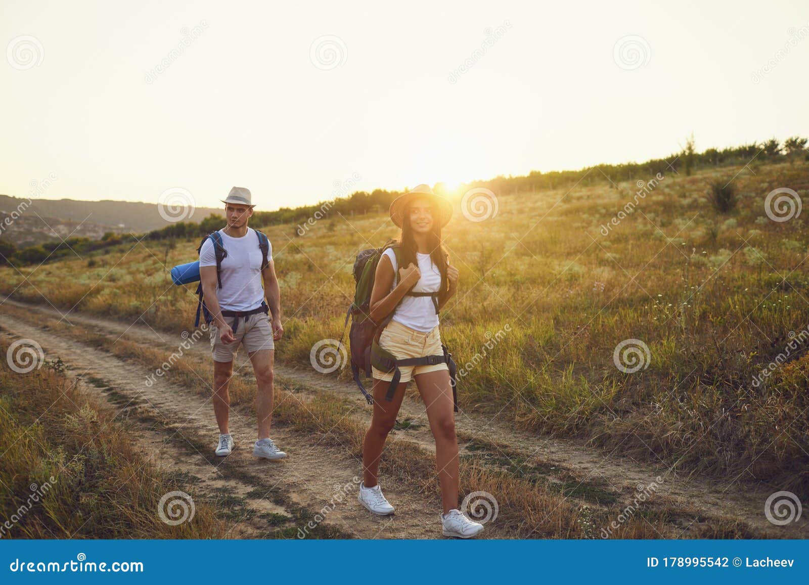 Couple with Backpack Walking on Hike in Nature at Sunset with the Sun. Stock Photo of freedom: 178995542