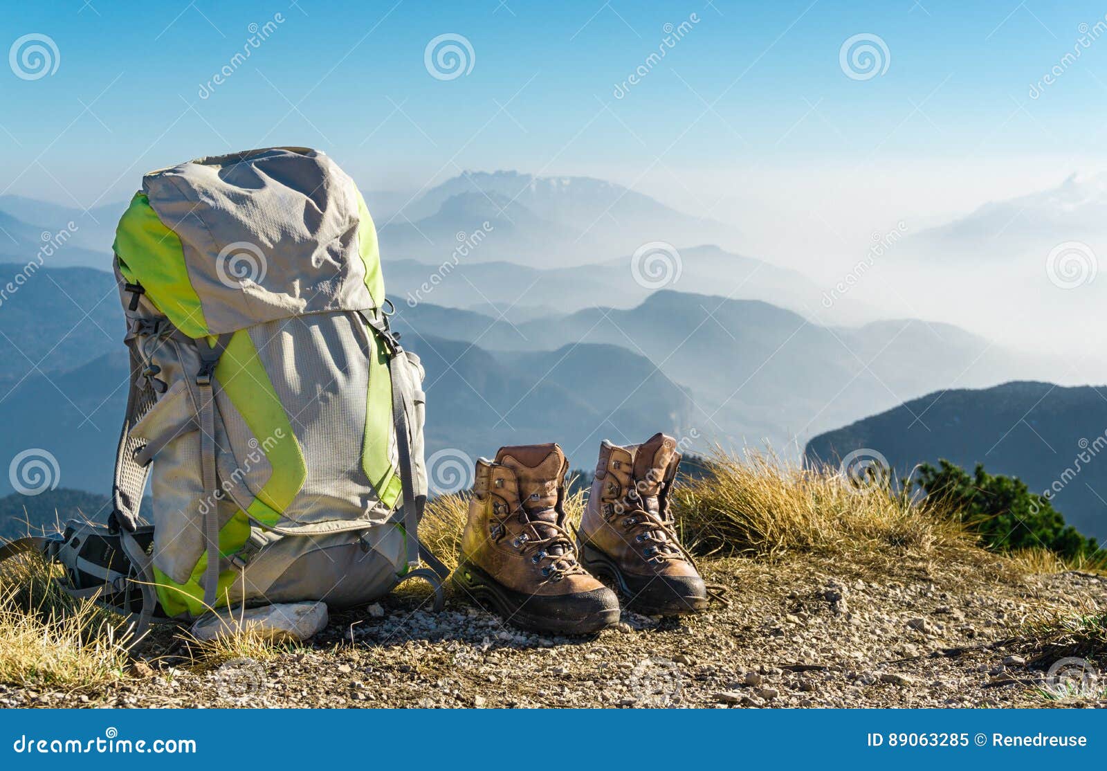hiking equipment. backpack and boots on top of mountain.