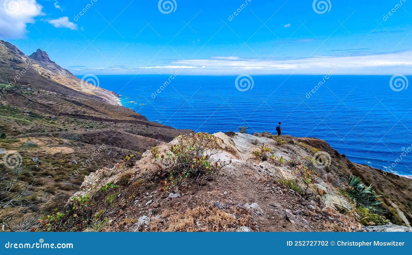 hiking man with scenic view of coastline of anaga mountain range on tenerife, canary islands, spain. view on cabezo el tablero